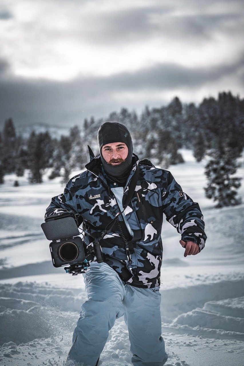 A man in winter gear running through snow in a snowy landscape