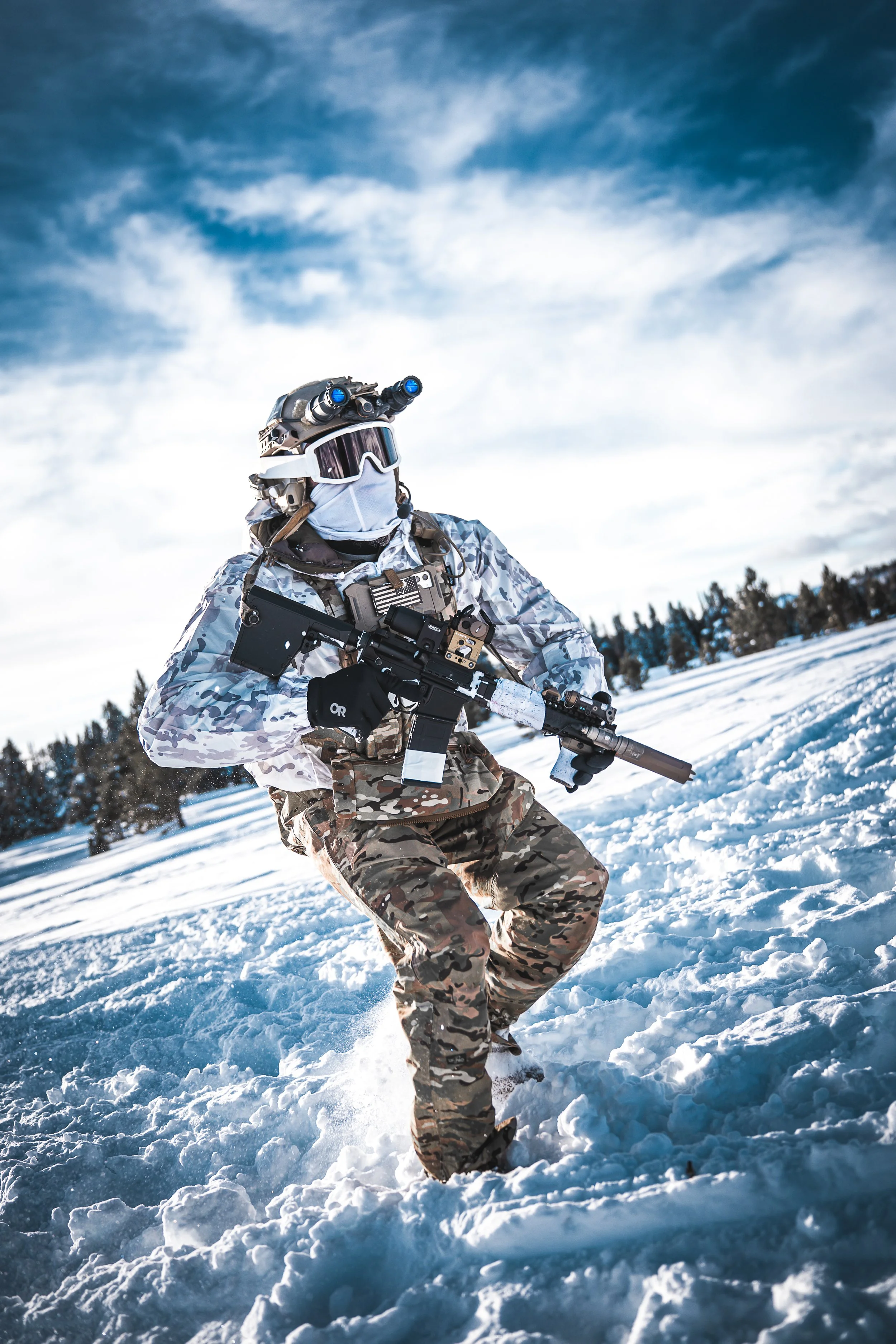 A soldier in camouflage gear and tactical equipment running through snow with a rifle in hand.