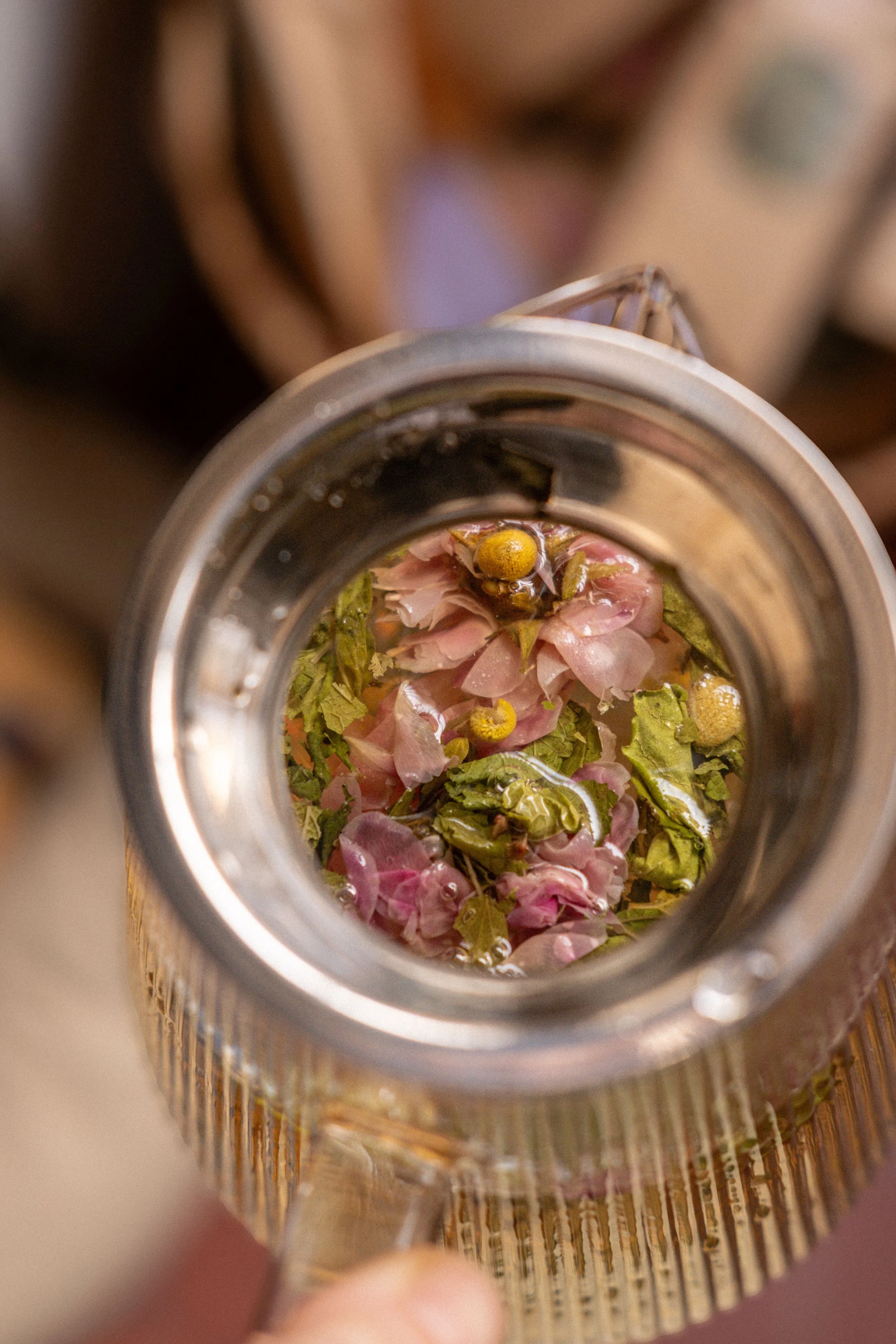 Vue plongeante d'un bocal en verre contenant des fleurs séchées et de l'eau.
