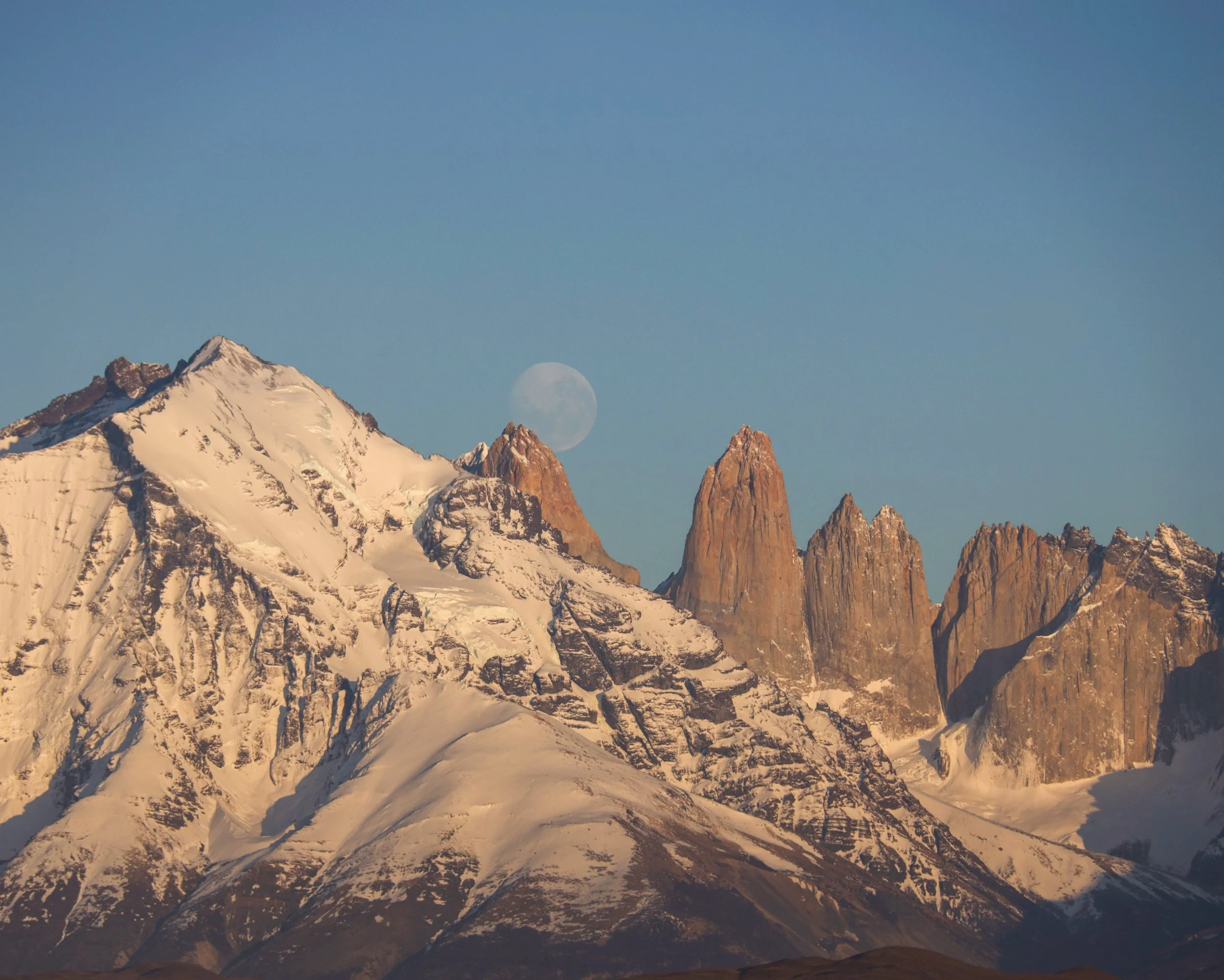 Sunset view of the Alhambra palace and fortress in Granada, Spain, with mountains in the background.