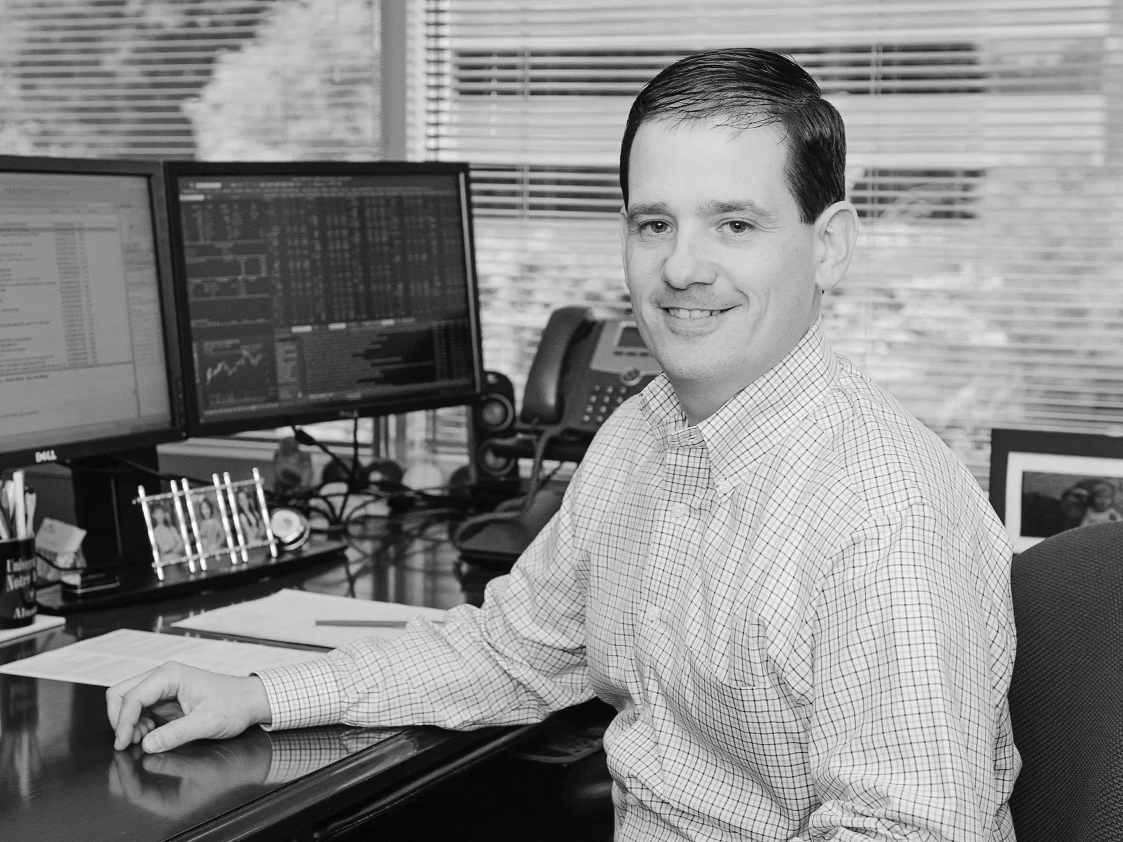 Dominic Marshall, a smiling man sitting in front of two computer monitors