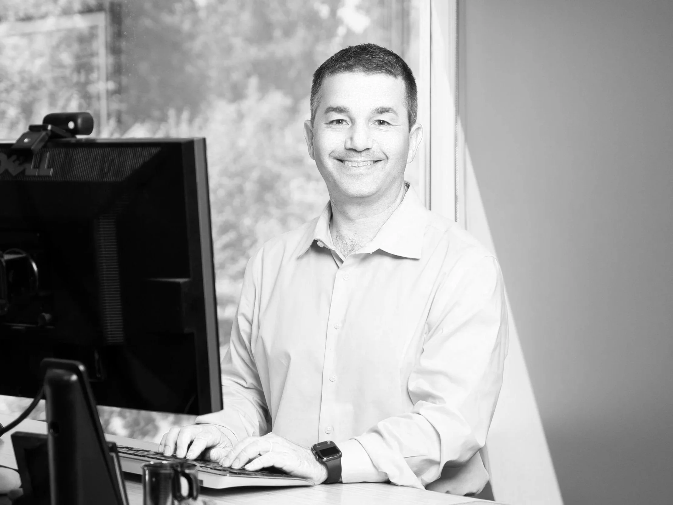 Ryan Curdy, a man sitting at a desk with his hands on the keyboard