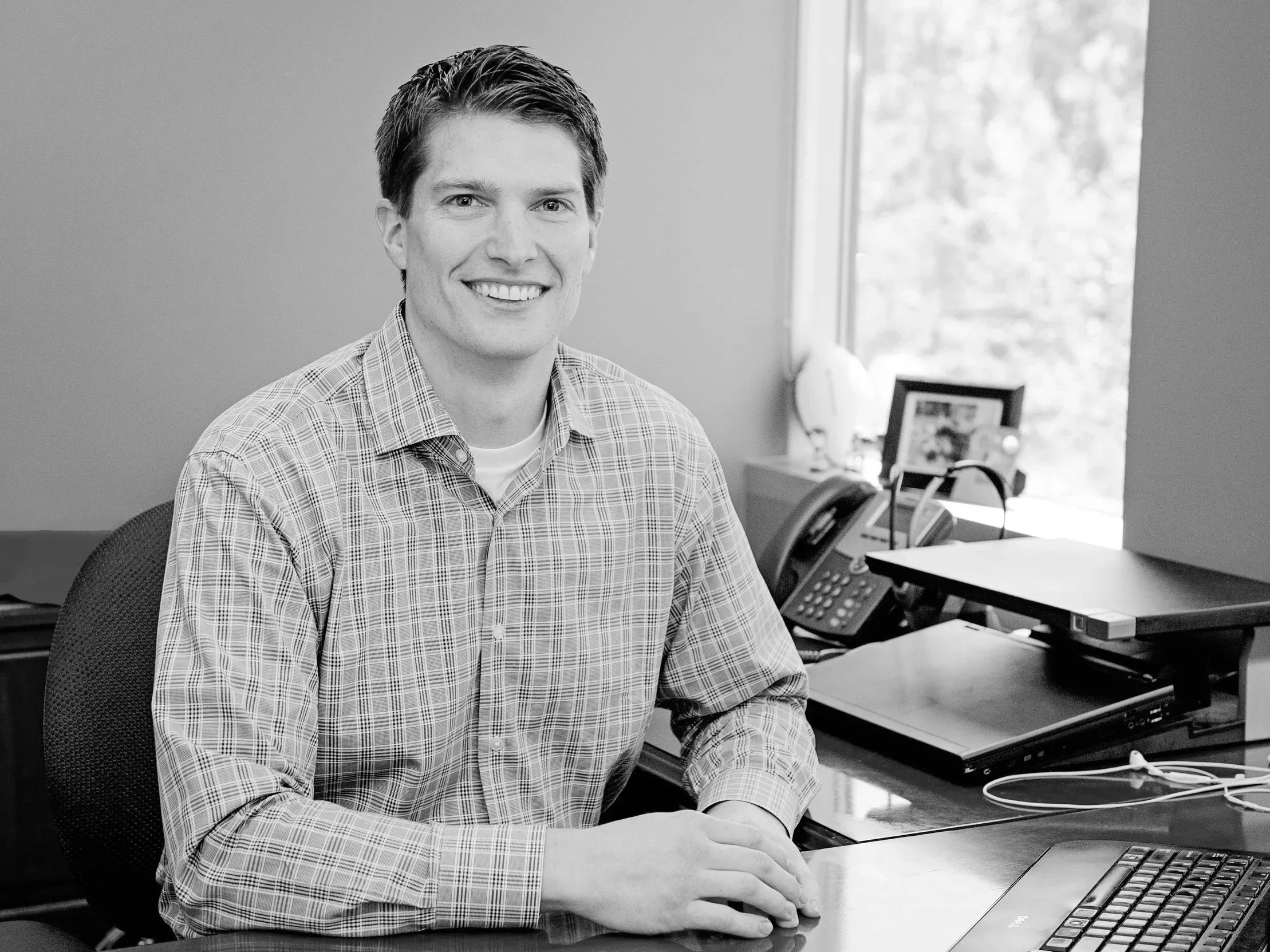 Justin McKillip, a smiling man sitting at a desk