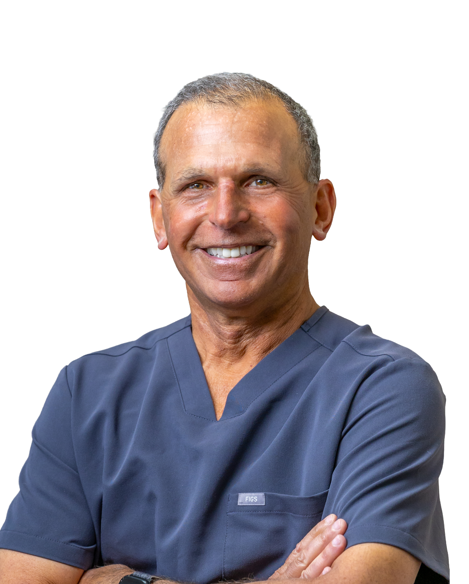 A middle-aged man in medical scrubs smiling with arms crossed in front of a white background.