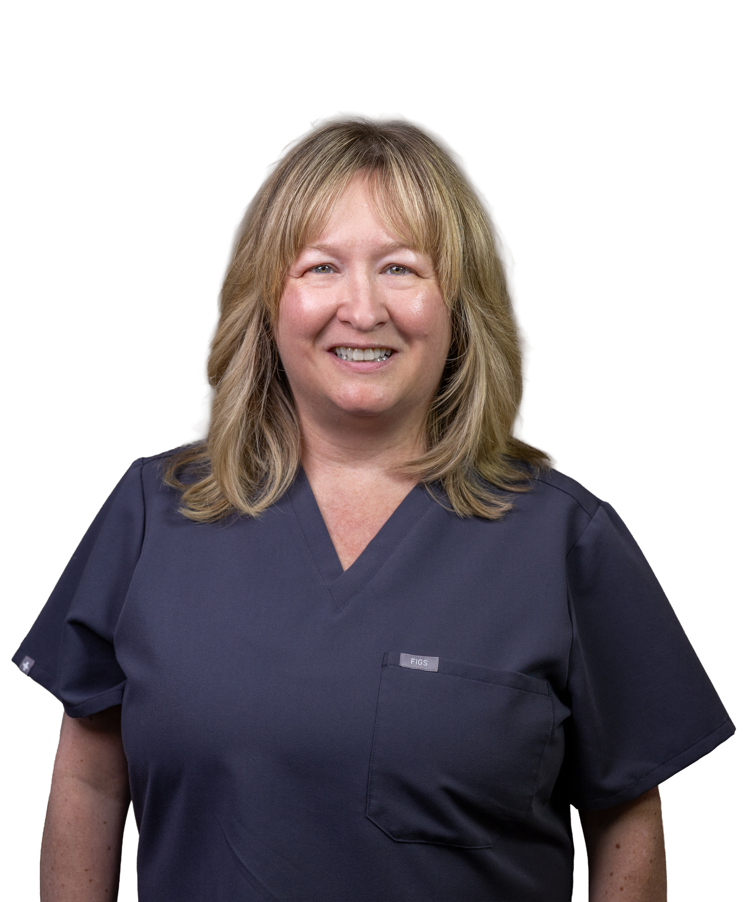 A woman with shoulder-length blonde hair wearing a navy blue medical scrub top, smiling with teeth showing.