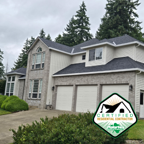 A two-story house with brick and siding exterior, multiple garage doors, and large windows, set against a backdrop of tall evergreen trees on a cloudy day. malarkey roof, certified, roof parts, fix leak