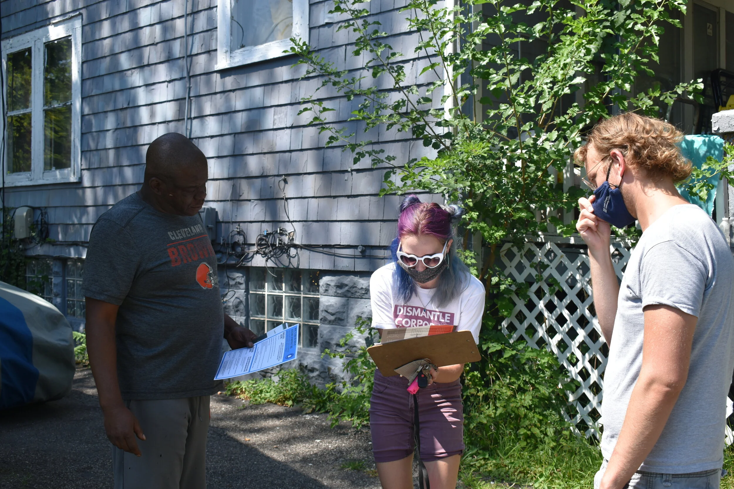From left to right, Cleveland resident Frank Hawkins talks to Cleveland DSA members Anna Powaski and Chad Falatic about the home he was renting and the problems he was having with his landlord back in August. Photo by Conor Morris.