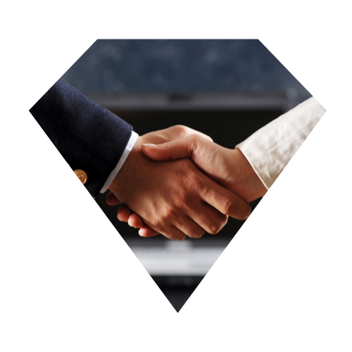 Apretón de manos entre dos personas, una con traje oscuro y la otra con blusa blanca.