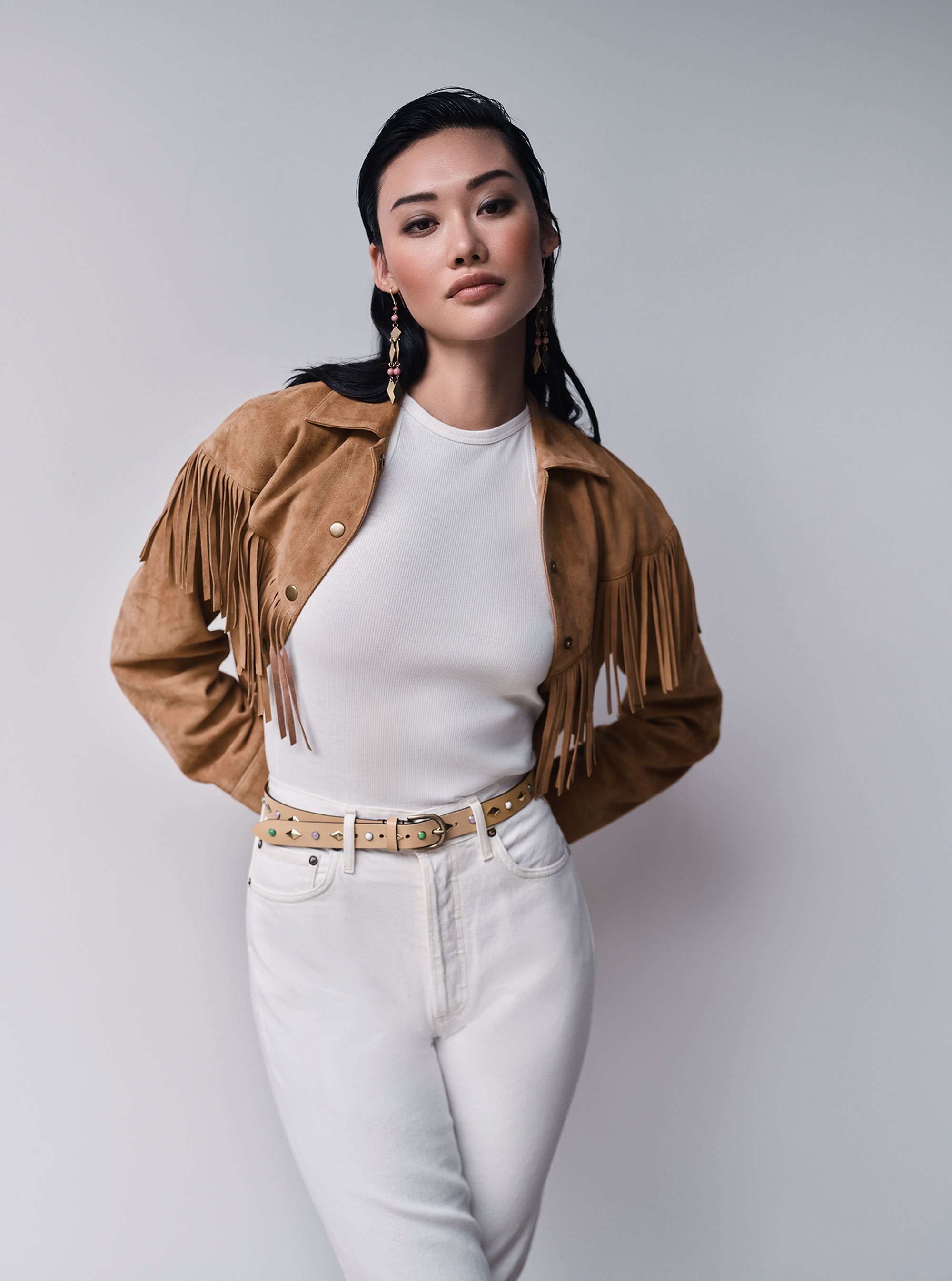 Woman in Intermix fringed jacket and white shirt and denim