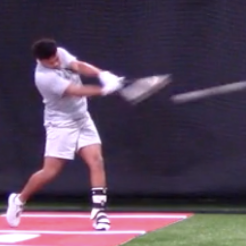 Person swinging a golf club indoors on a mat