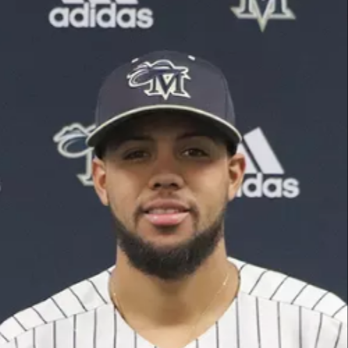 Young man in a baseball uniform and cap, standing in front of a backdrop with adidas and sports team logos.