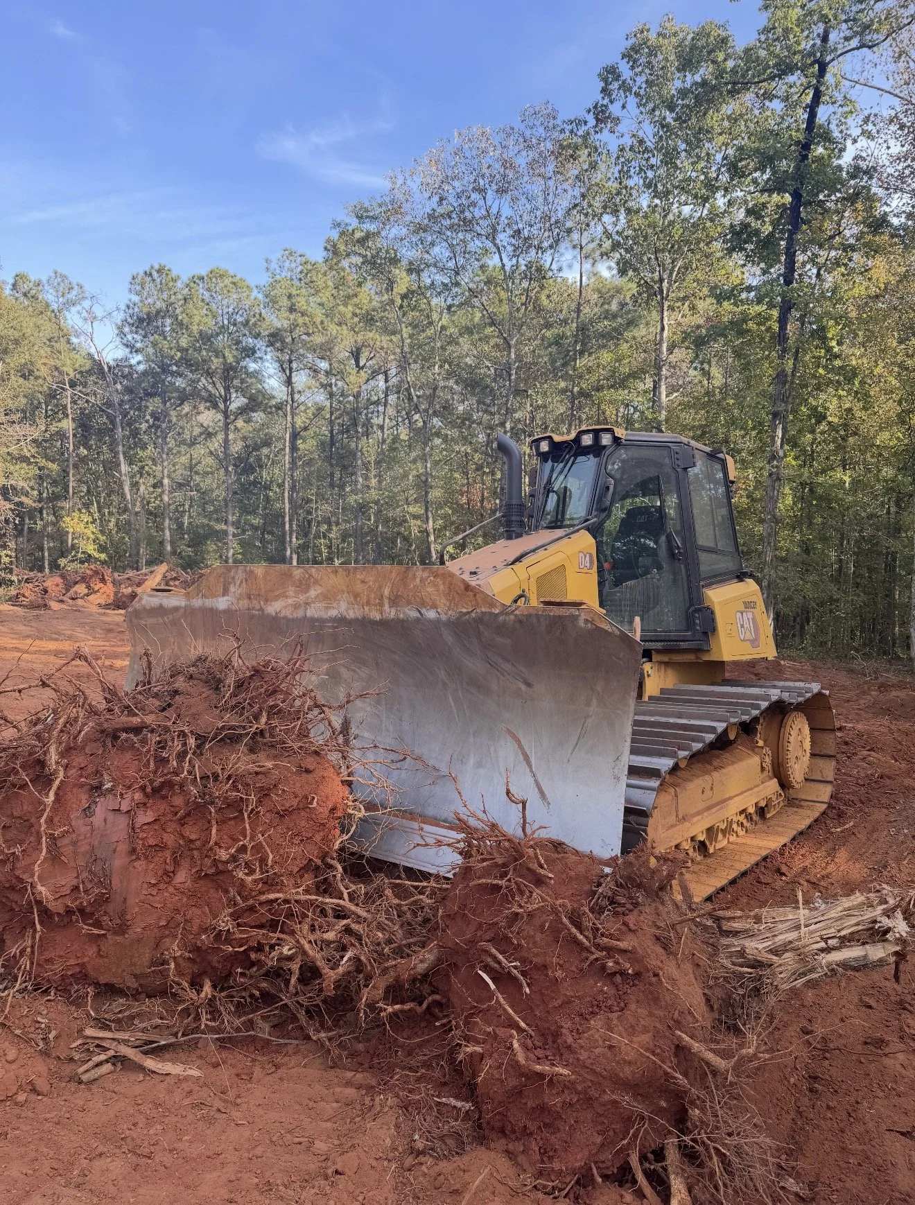 Bulldozer land clearing, tree root removal, and site preparation completed for future property development in Middle Georgia.