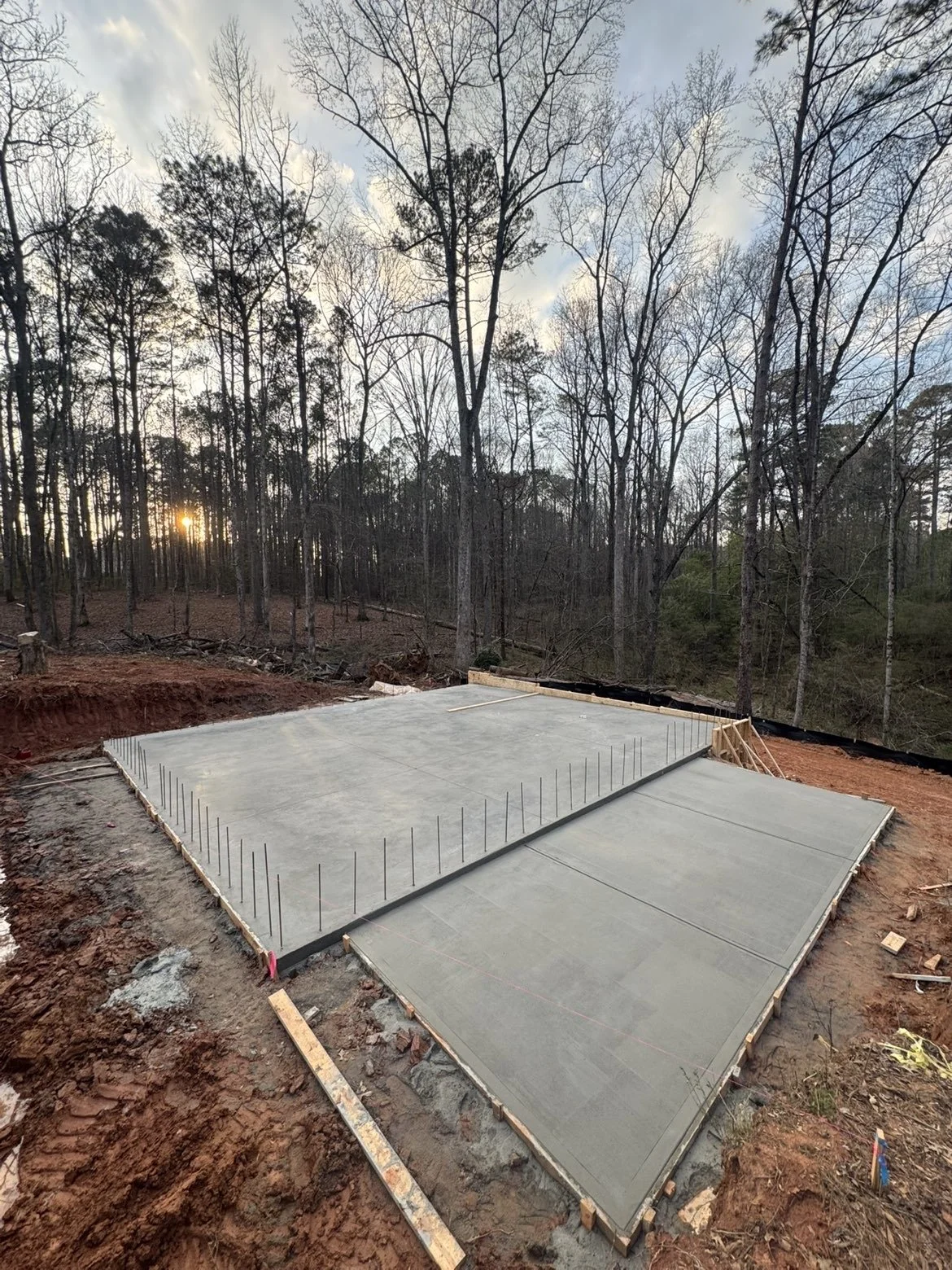 Concrete foundation slab installation completed with rebar reinforcement and site preparation for a new construction project in Middle Georgia.