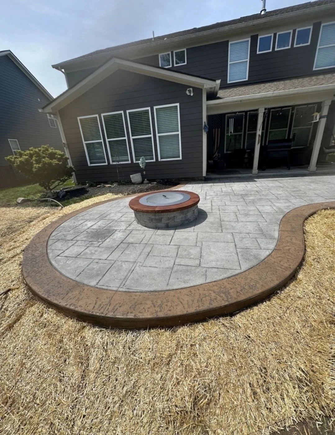 Stamped concrete patio and custom fire pit installation completed to create a functional outdoor living and entertainment space in Middle Georgia.