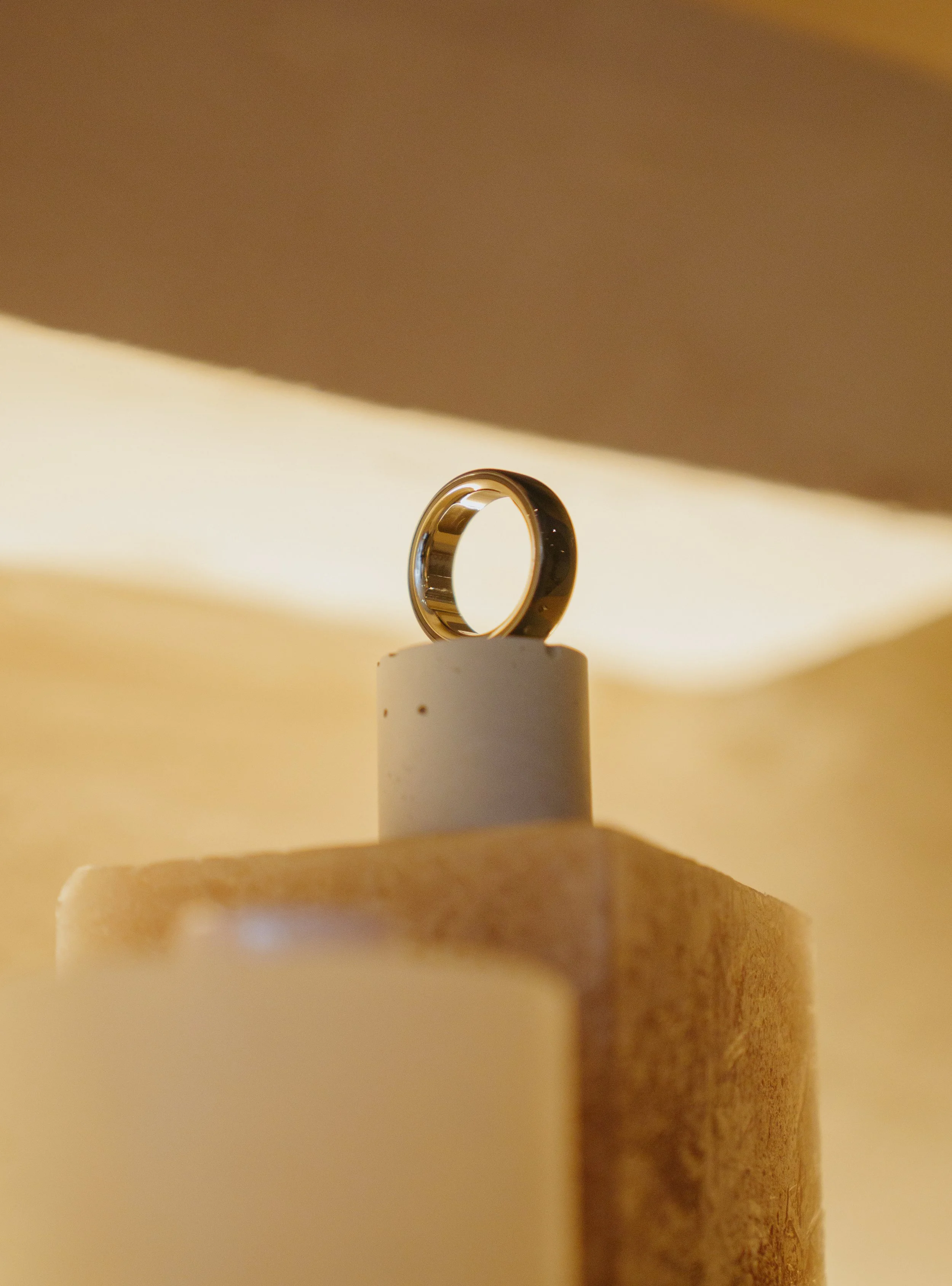 OURA - Ceramic ring, hero shot of ring on stand.jpeg