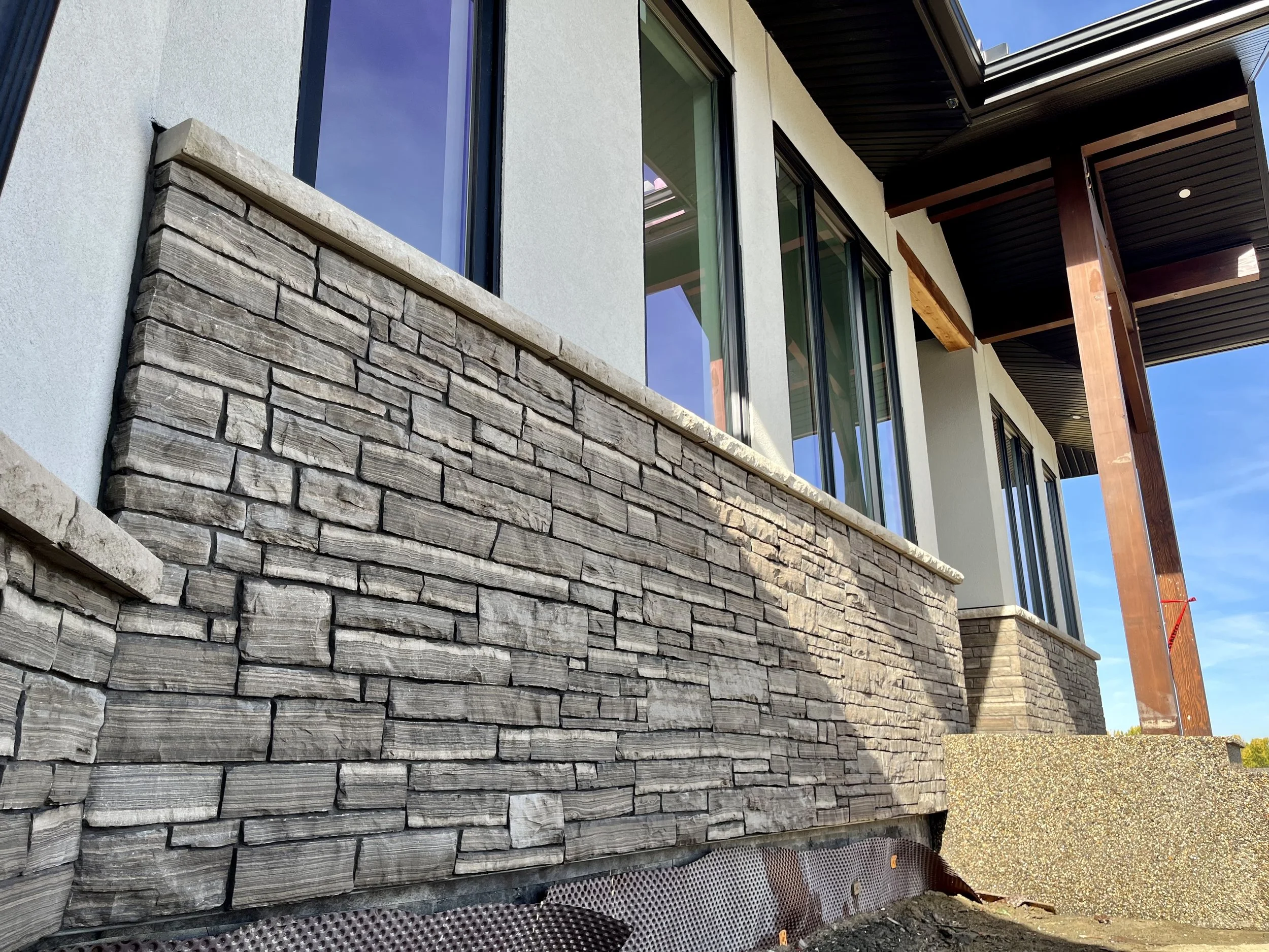 Modern house exterior with stone veneer wall and large windows