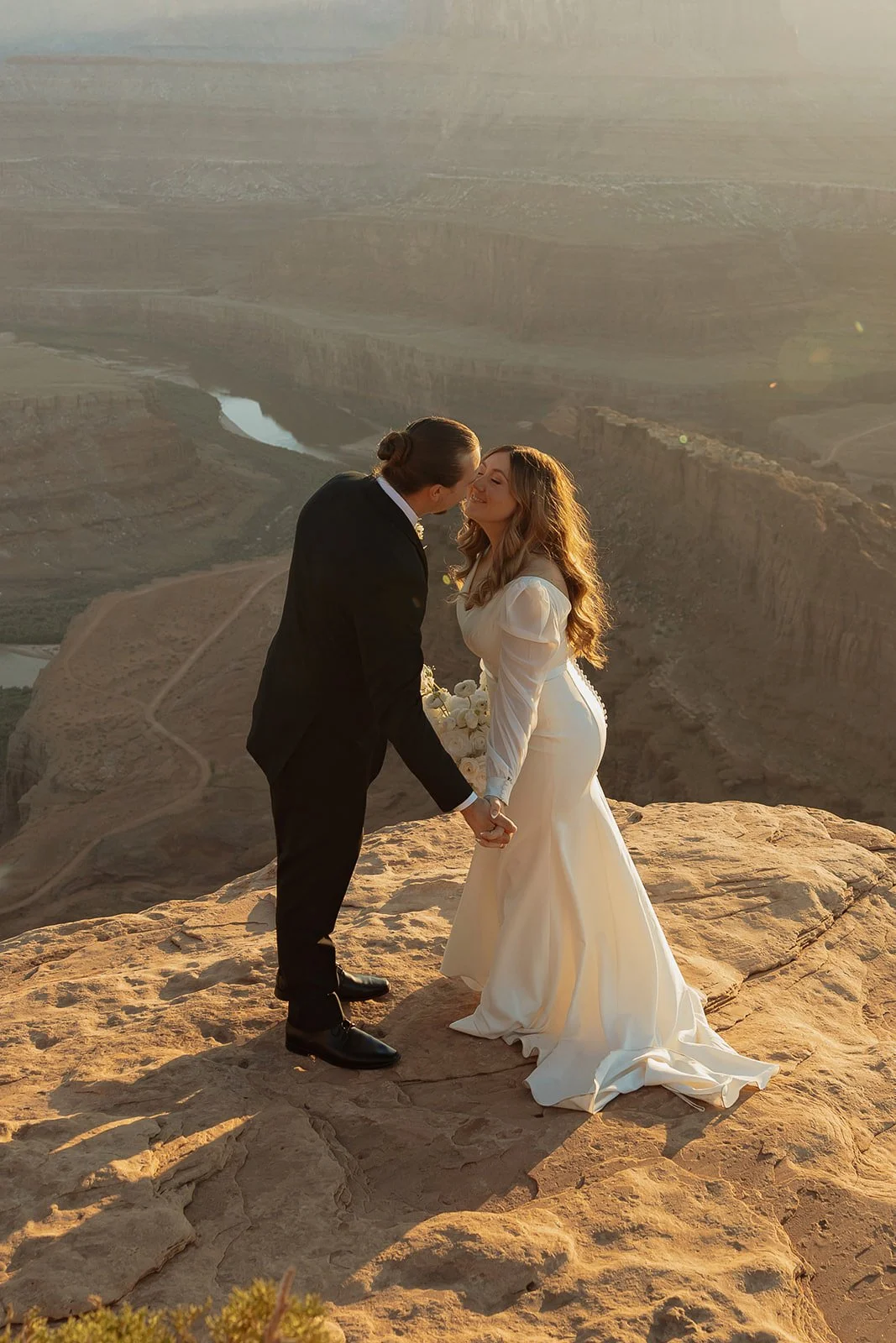 bride and groom eloping cliffside in Moab, Utah at Dead Horse Point