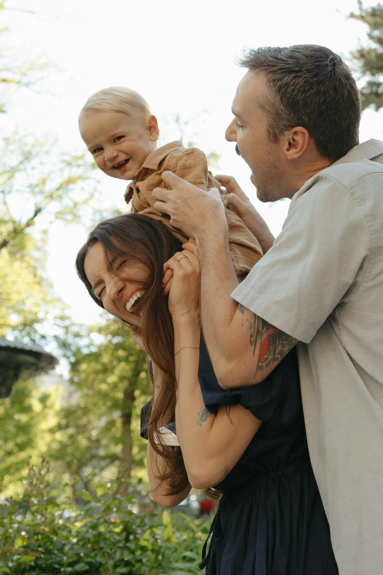 family of three laughing during a family session in downtown salt lake city