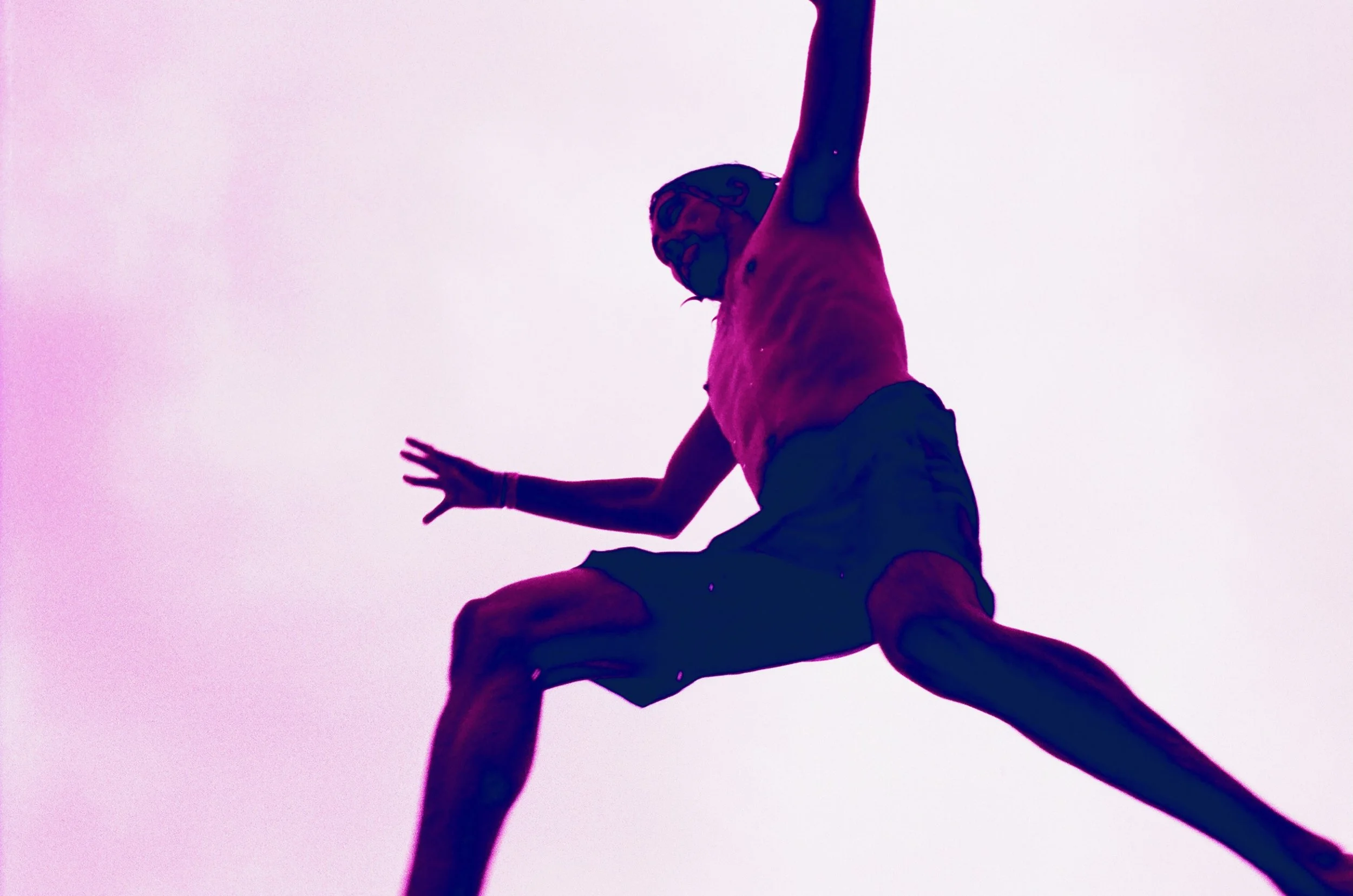 A silhouette of a person climbing a pole against a pink sky, with the person's body bent and one arm reaching upward.