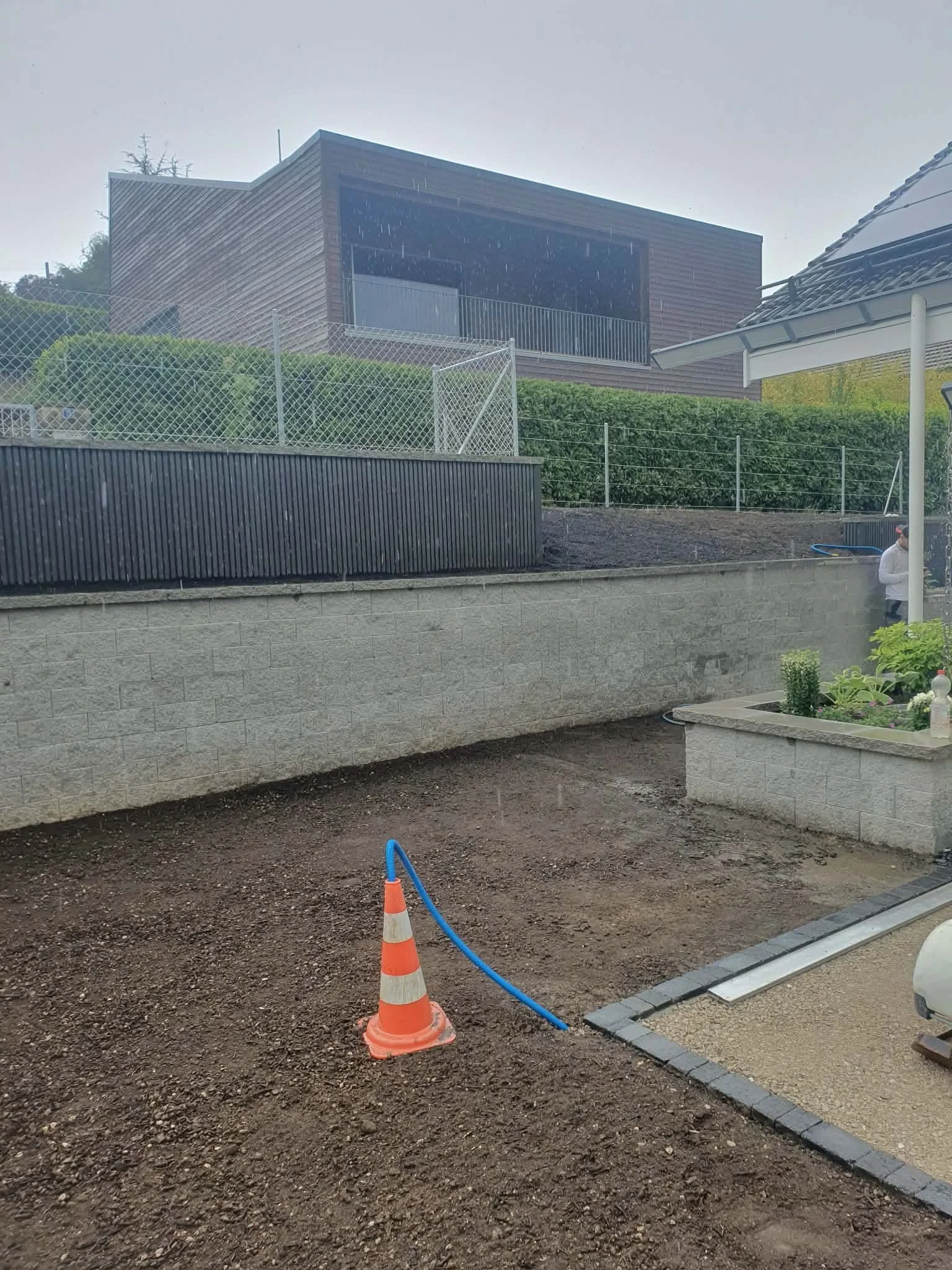 Mur de soutènement + Bardage en bois stratifié + Pose d'une cloture souple