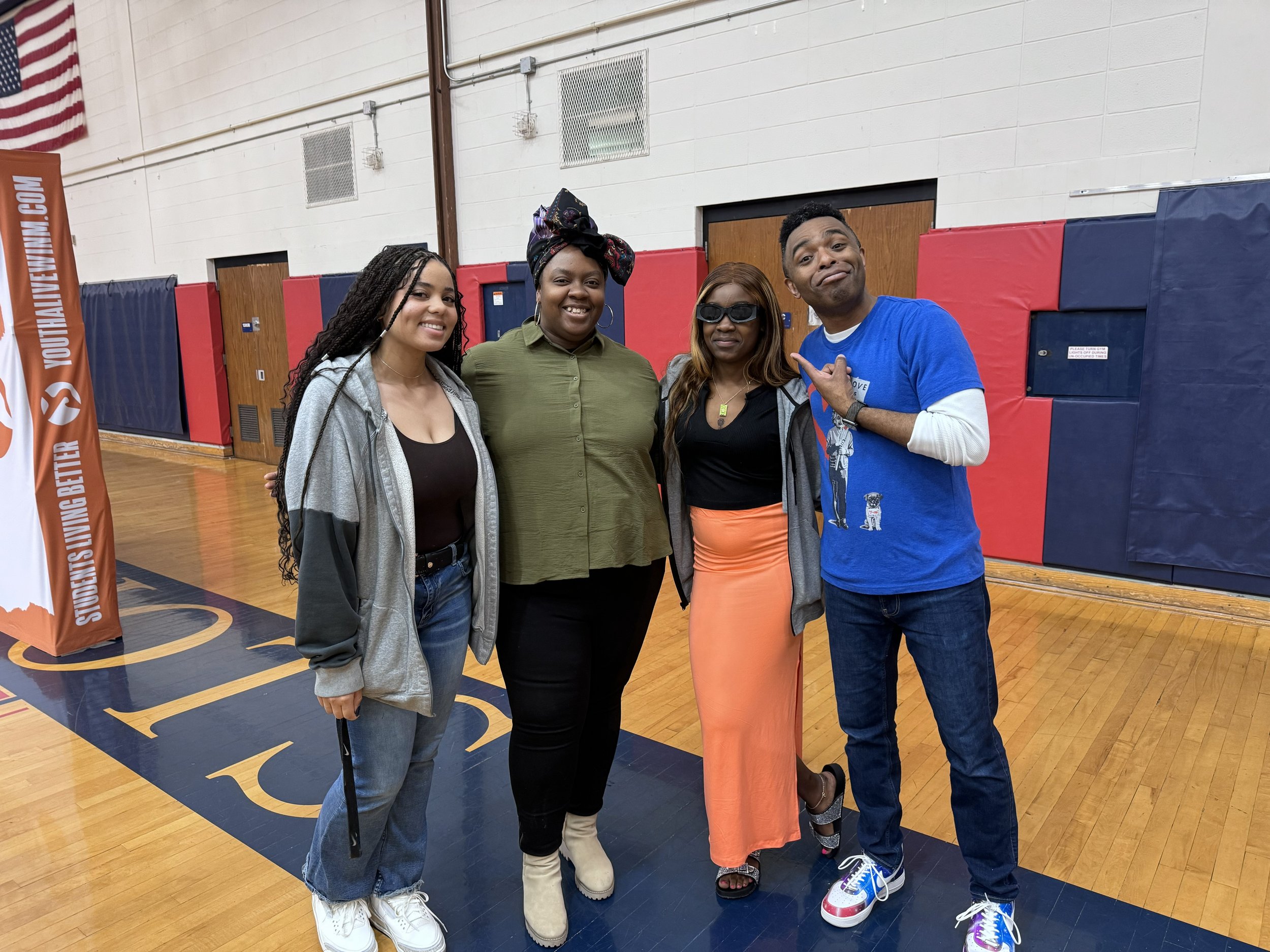 Terrence Talley in a group of people standing on a gymnasium basketball court, smiling for a photo.