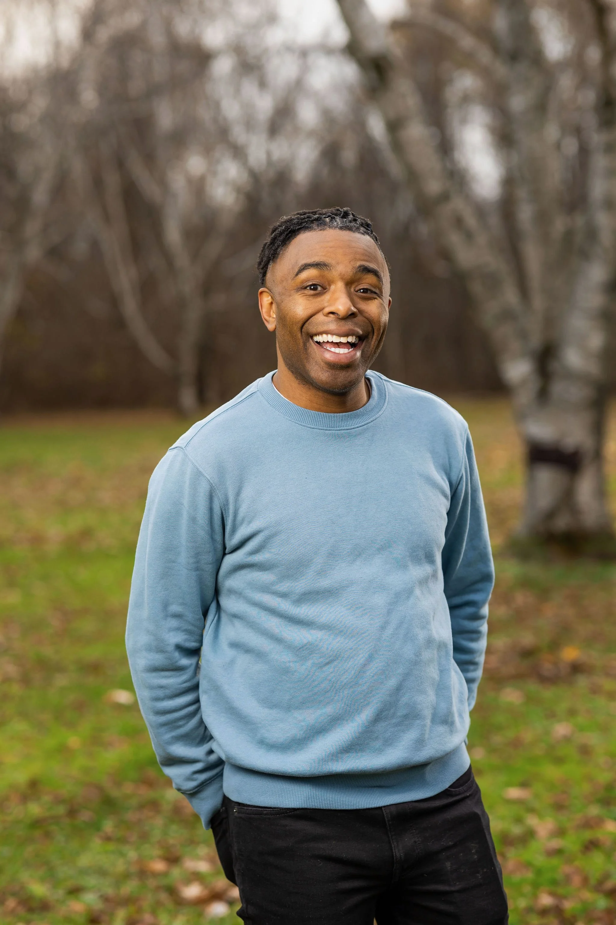 Terrence Talley standing outdoors in a park with trees in the background.