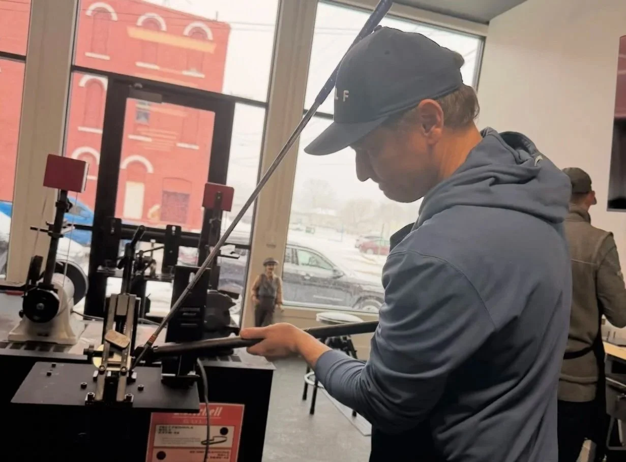 Worker bending the loft & lie of a golf club