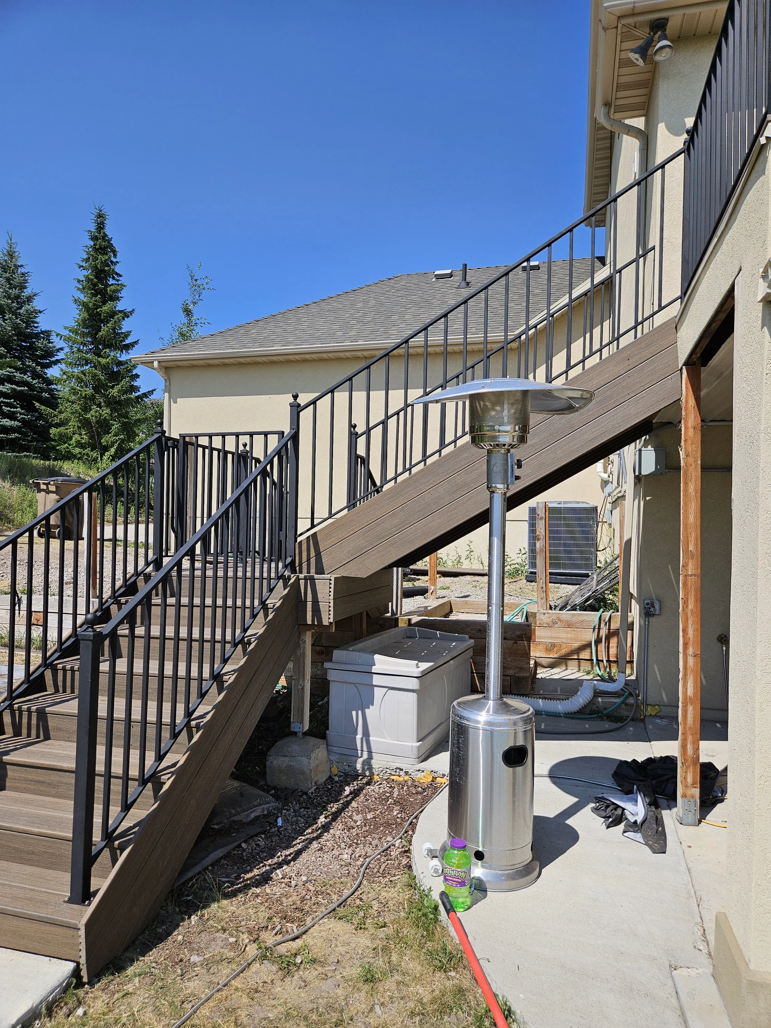 Outdoor patio area with a staircase, a patio heater, and some miscellaneous items on the ground in Payson, UT.