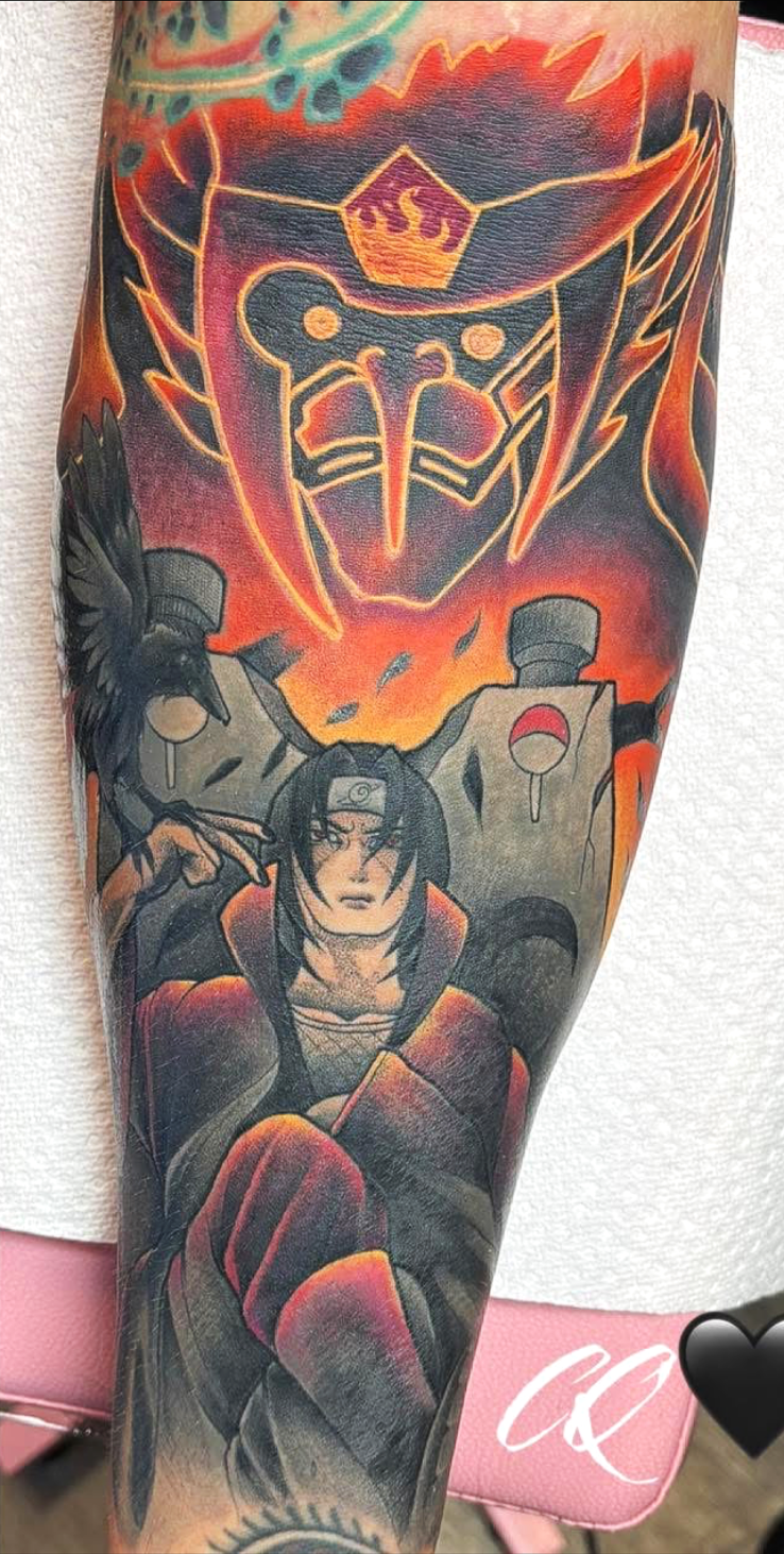 Colorful tattoo featuring an anime character with dark hair, wearing a headband, sitting with a serious expression, surrounded by a crow and a large red and orange fiery background with a stylized emblem overhead.