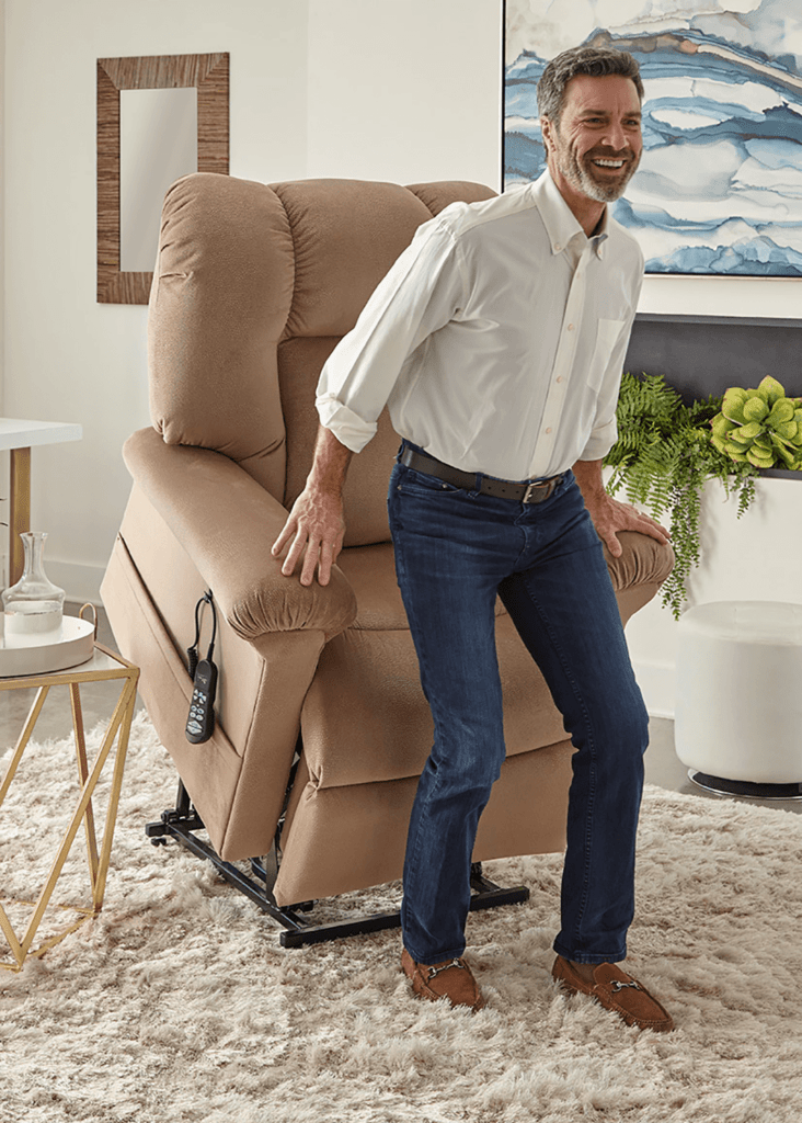 A lift reclining chair in use showing the lift feature helping a middle aged man stand up after his surgery.