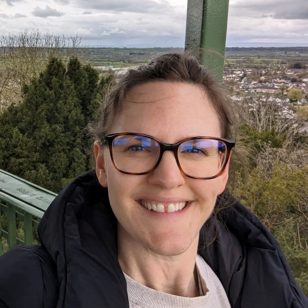 Profile of smiling woman Emma with glasses