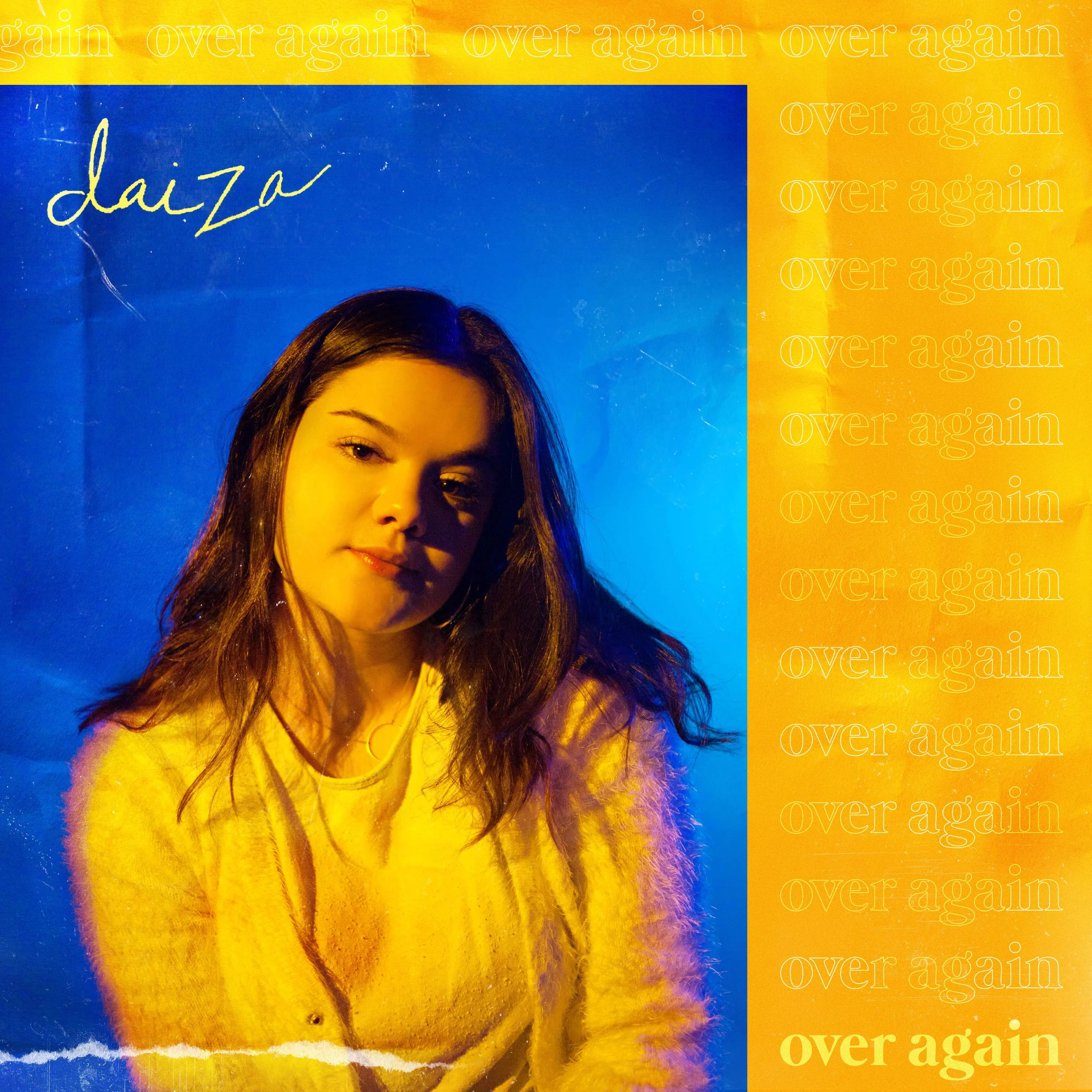 Close-up of a magazine cover featuring a woman's face with brown hair, set against a blue and yellow background with repeated text 'over again' and the handwritten signature 'daja'.