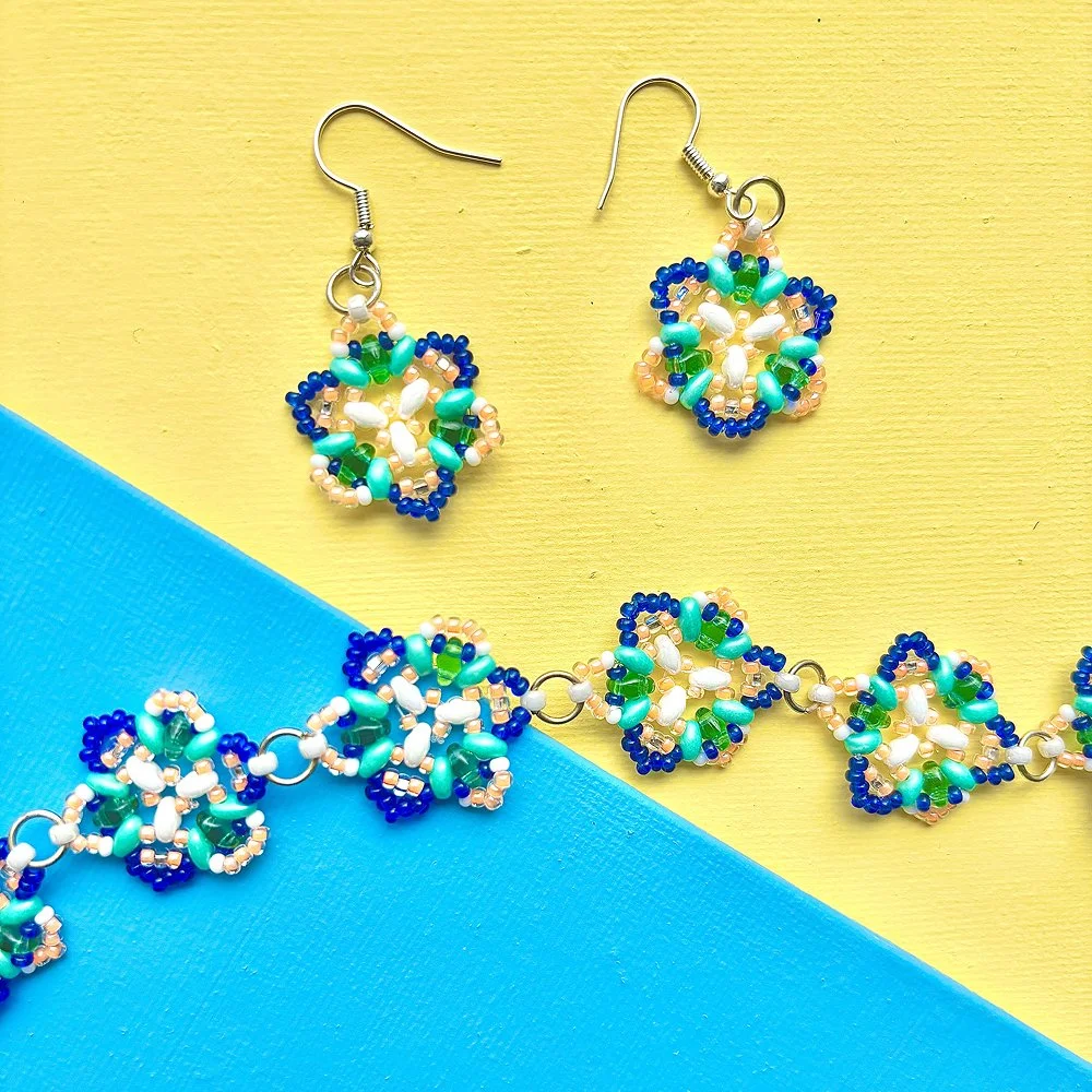 beaded trillium earrings and bracelet by lovely day crafts on a yellow and blue painted backdrop