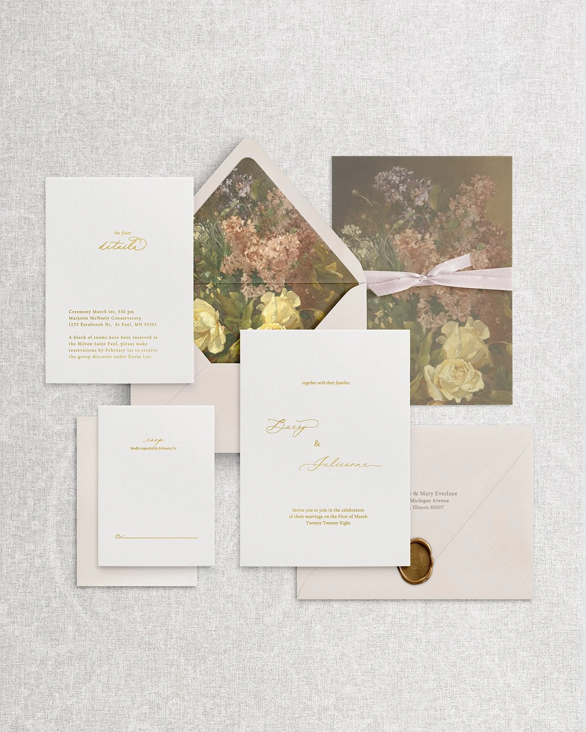 Flatlay of elegant, simple wedding invitation suite with gold foil calligraphy, main invitation, RSVP card, details card, and envelope with floral liner, blush silk ribbon and vintage gold wax seal.