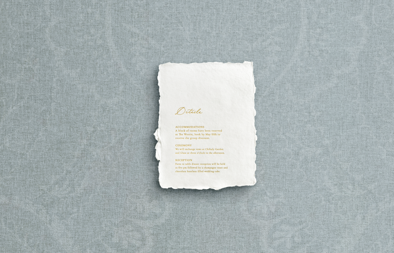 White details card on handmade paper with mixed typography of calligraphy printed using gold foil letter press on blue background.