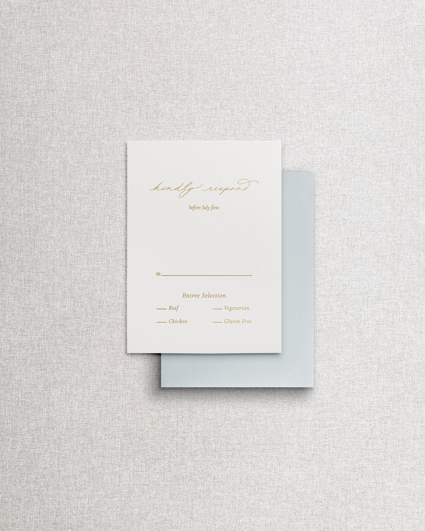 Elegant, simple wedding invitation RSVP card with gold foil calligraphy on textured cream paper.