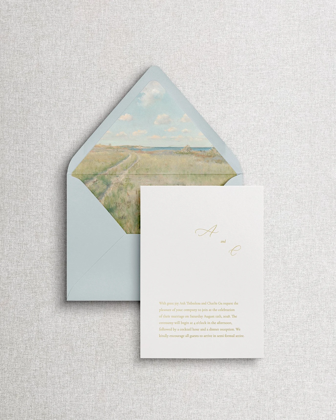 Elegant, simple wedding invitation with gold foil calligraphy and a seaside envelope liner.