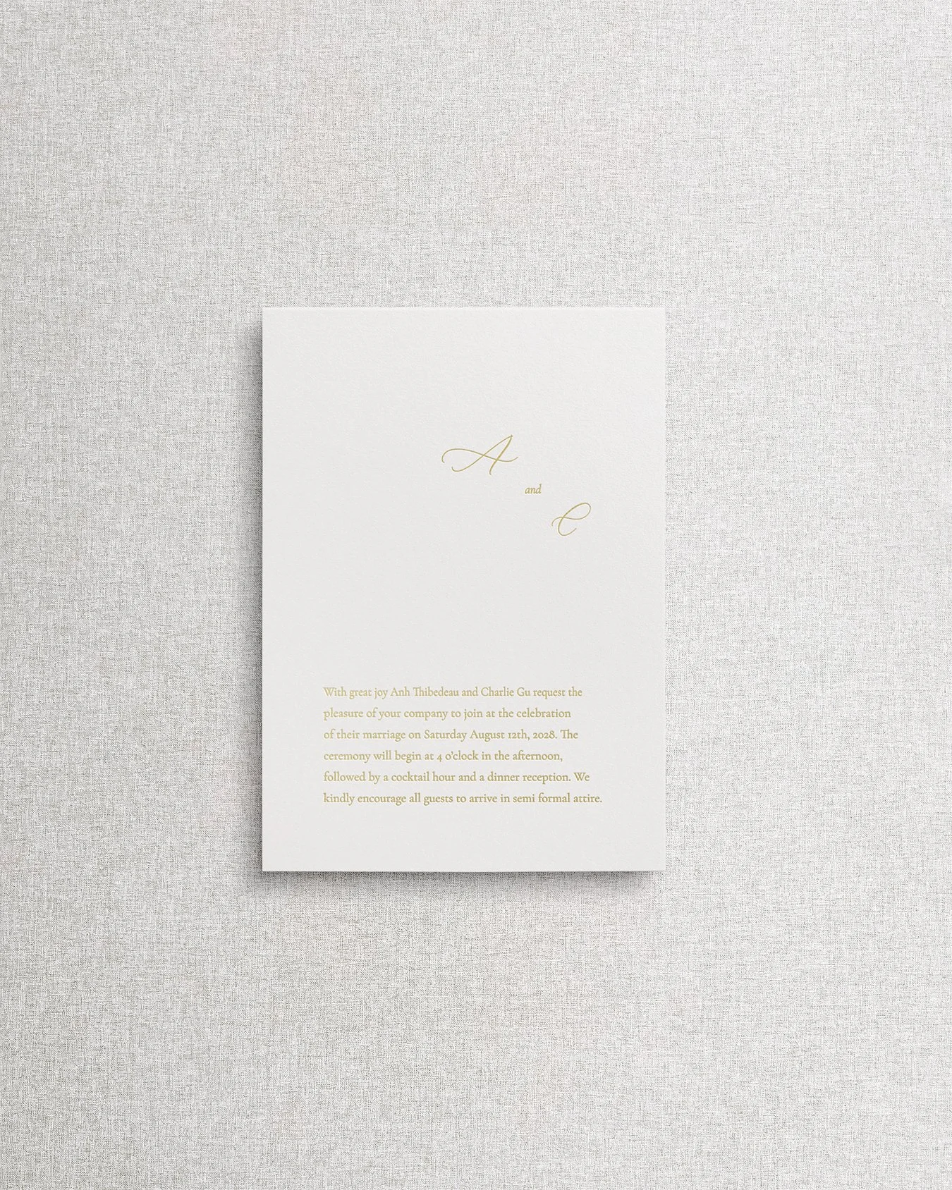 Elegant, simple wedding invitation card with gold foil calligraphy on textured cream paper.