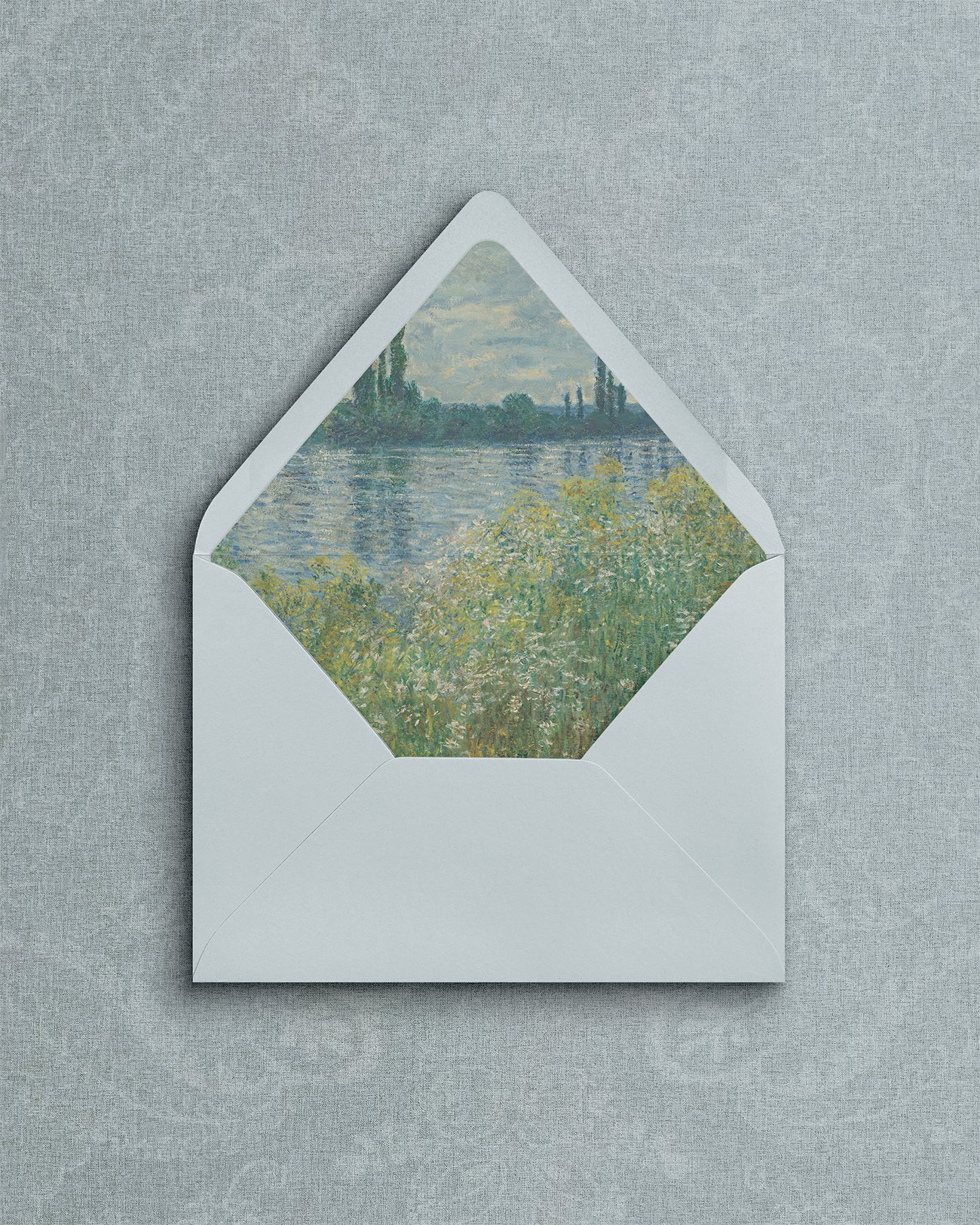 Dusty blue envelope with floral waterscape.