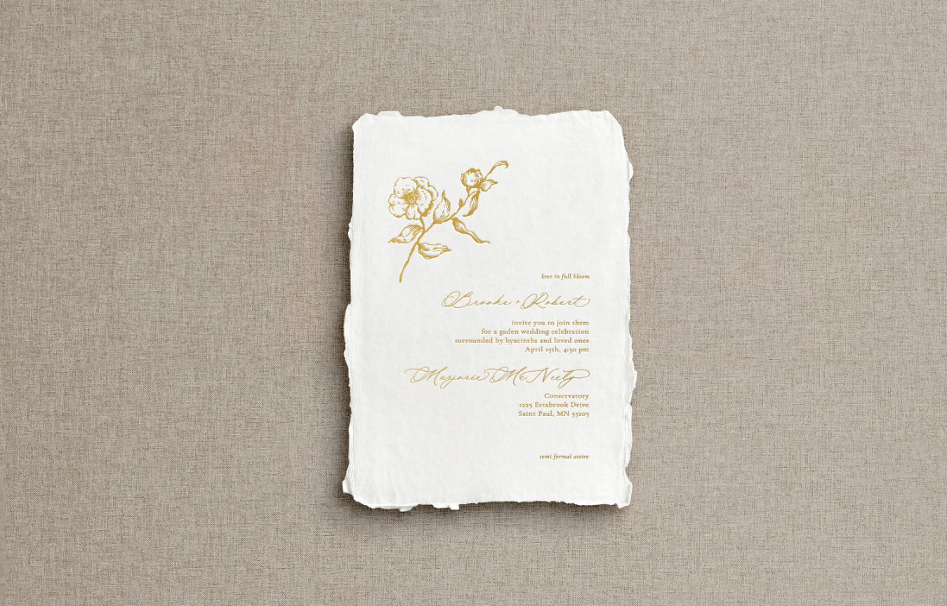Main invitation on white handmade paper with gold letterpress featuring fine art sketch of rose in upper corner with mix of calligraphy text.