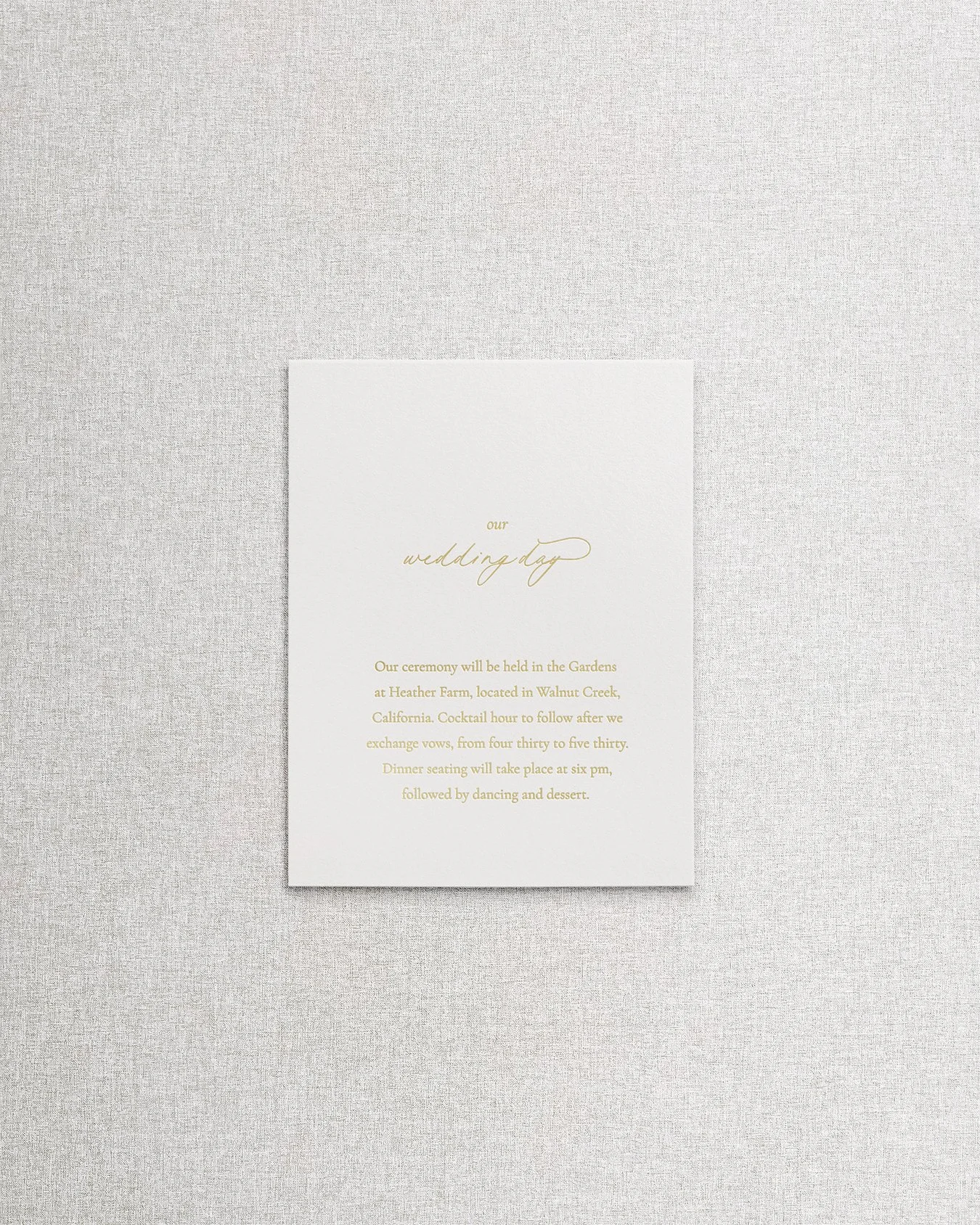 Elegant, simple wedding invitation details card with gold foil calligraphy on textured cream paper.