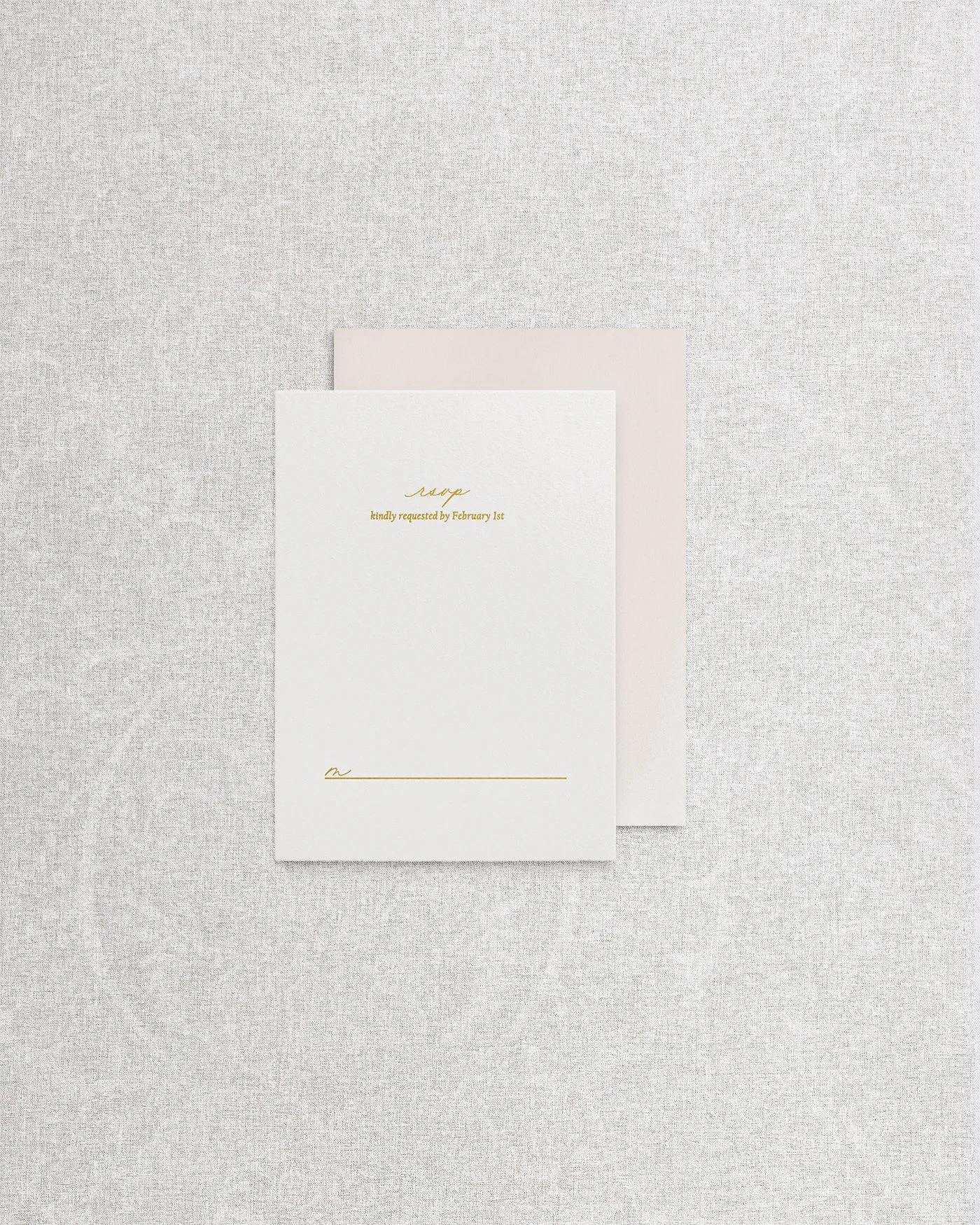 An elegant, simple wedding invitation RSVP card featuring sophisticated gold foil calligraphy on premium cardstock.