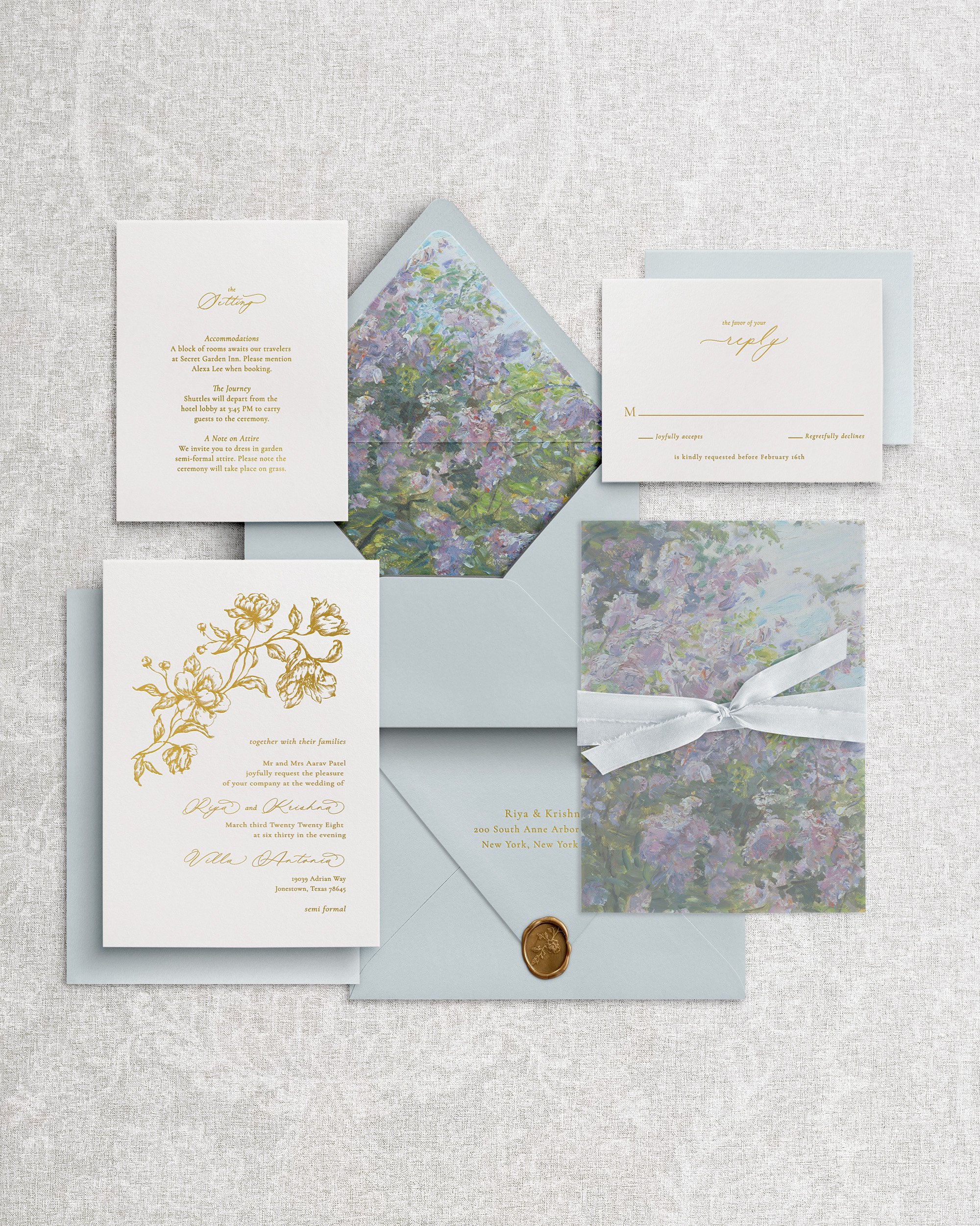 Premium wedding invitation: white cotton cardstock with floral debossing and gold foil letterpress calligraphy, plus a vellum wrap, dusty blue silk ribbon, and a matching wax seal.
