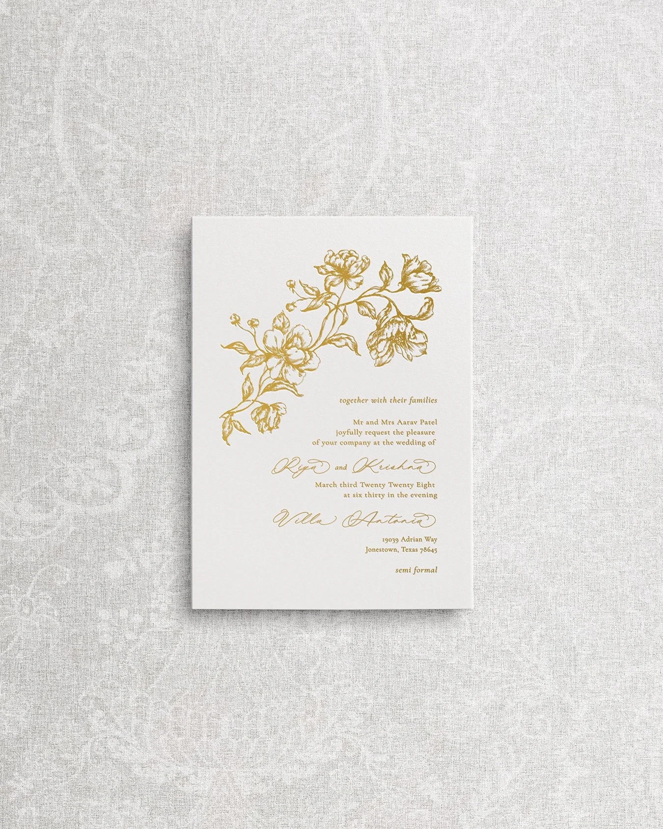 Wedding invitation printed using gold foil letterpress on premium cardstock, featuring calligraphy and fine art florals.