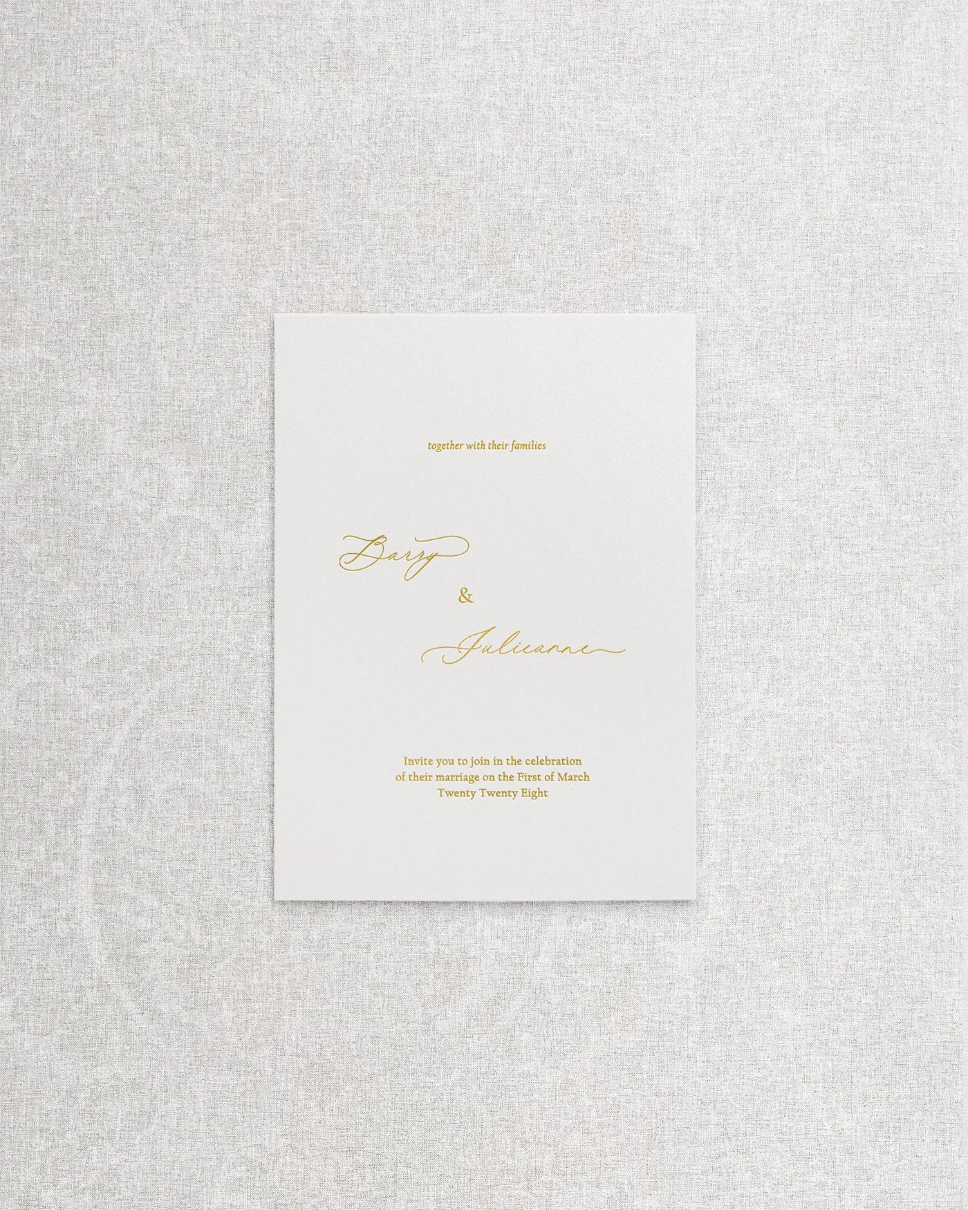 An elegant, simple wedding invitation featuring sophisticated gold foil calligraphy on premium cardstock.
