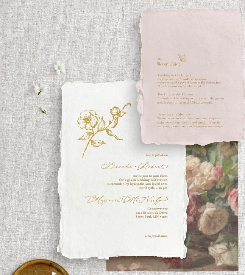 Fine art rose sketch in shimmering gold foil letterpress on handmade paper with deckled edges featuring a blend of fluid calligraphy and clean modern typography. A blush pink details card rests nearby.