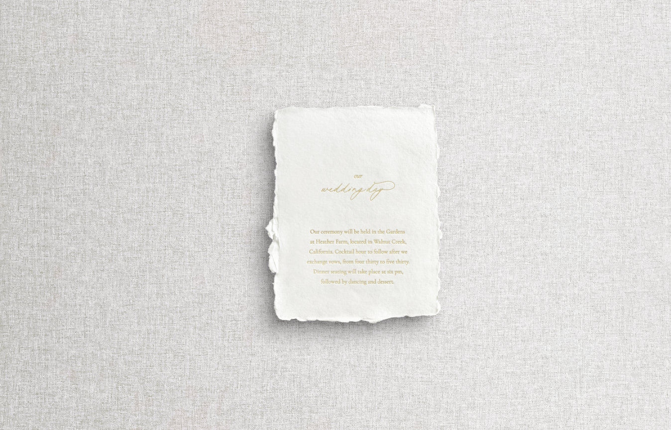 white details card on handmade paper with mix typography including calligraphy using gold foil letter press on neutral gray background.