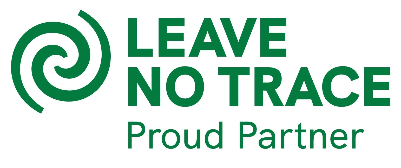 A green logo with a spiral symbol and the text "Leave No Trace" and "Proud Partner" in bold letters.