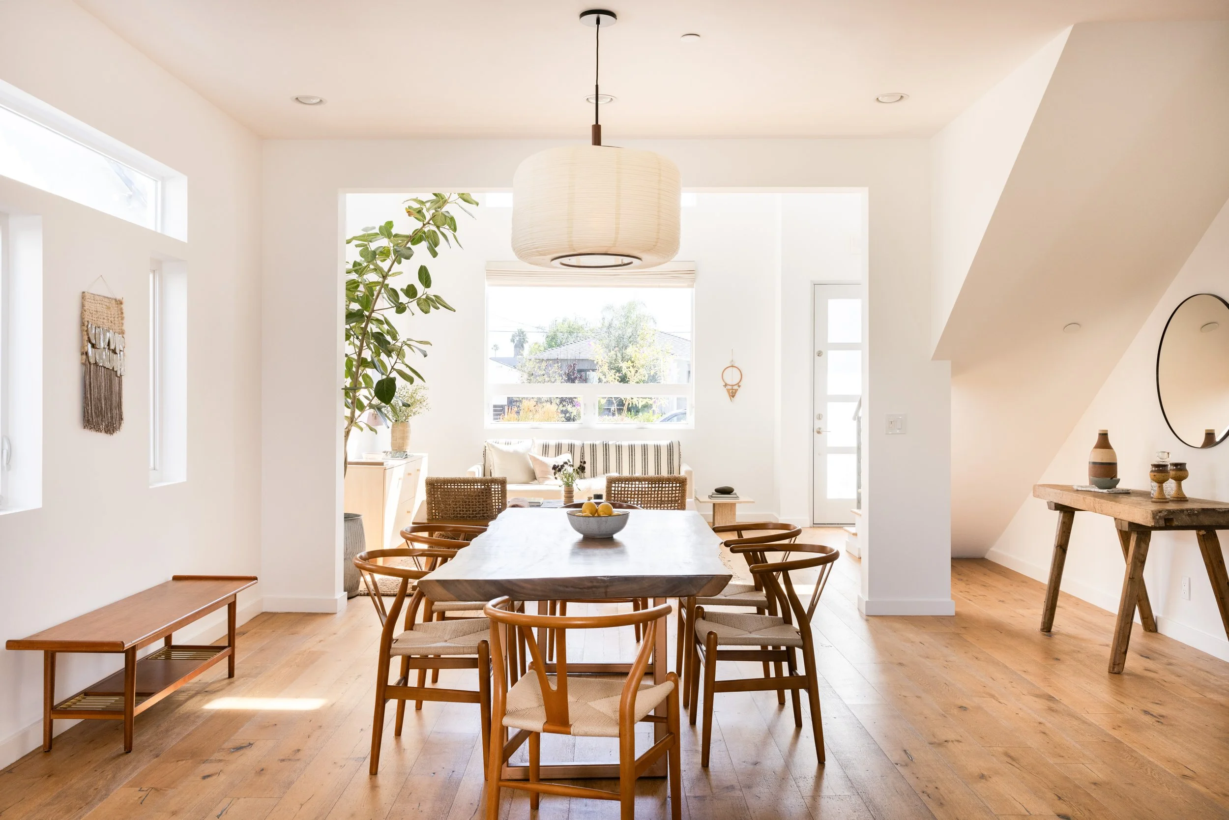 Bright dining room with wooden table and chairs, large window, and minimal decor.