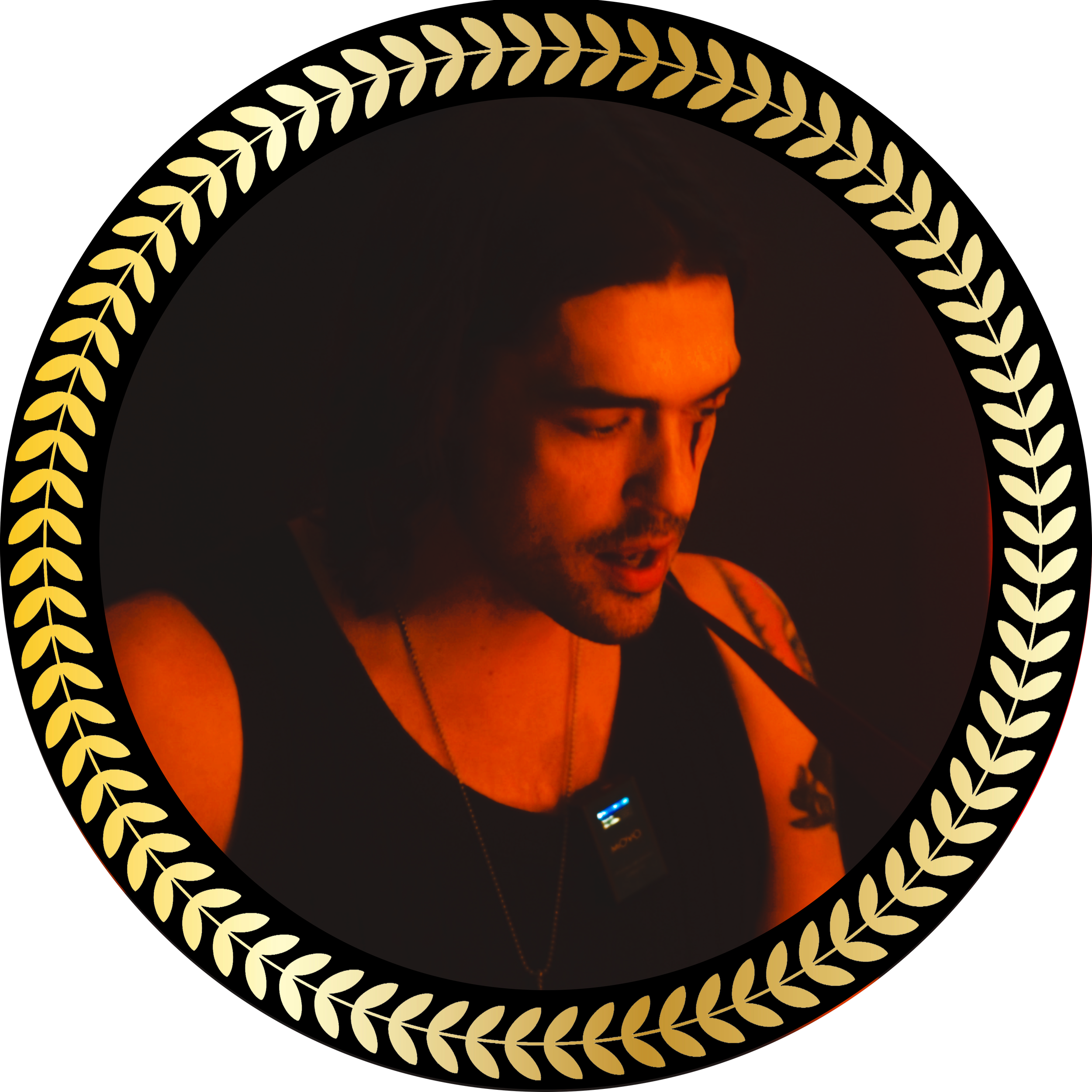 A man with tattoos on his arm, wearing a black tank top, looking down, illuminated by red lighting, set within a circular black background with a gold laurel border.